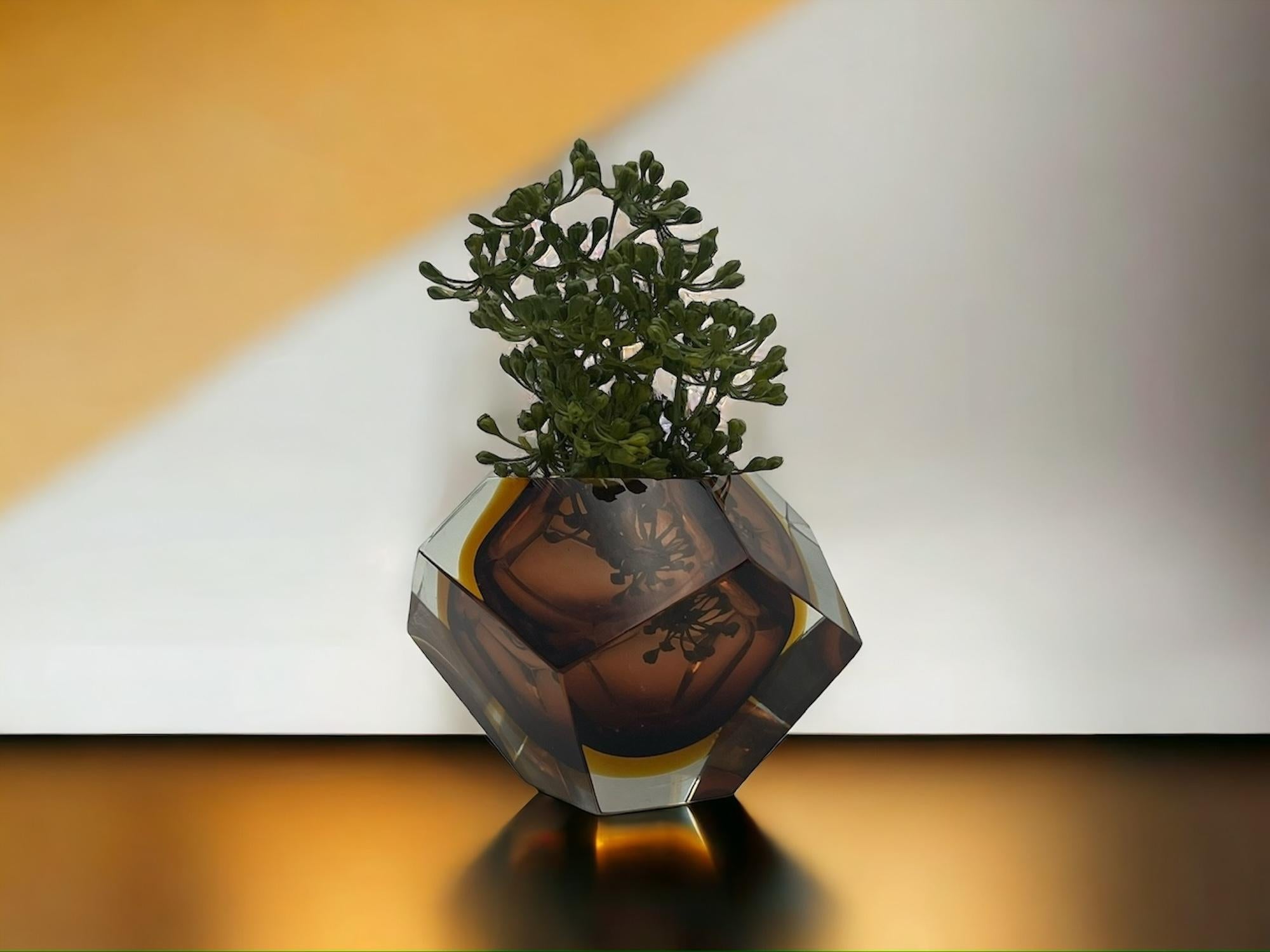 Lovely sculptural vase made of heavy ‘Sommerso’ Murano glass with the inimitable style of Fabio Poli for Seguso.

These refined vase features warm abd brilliant hues, with hazelnut brown and gold shades submerged into fume clear glass. The angular