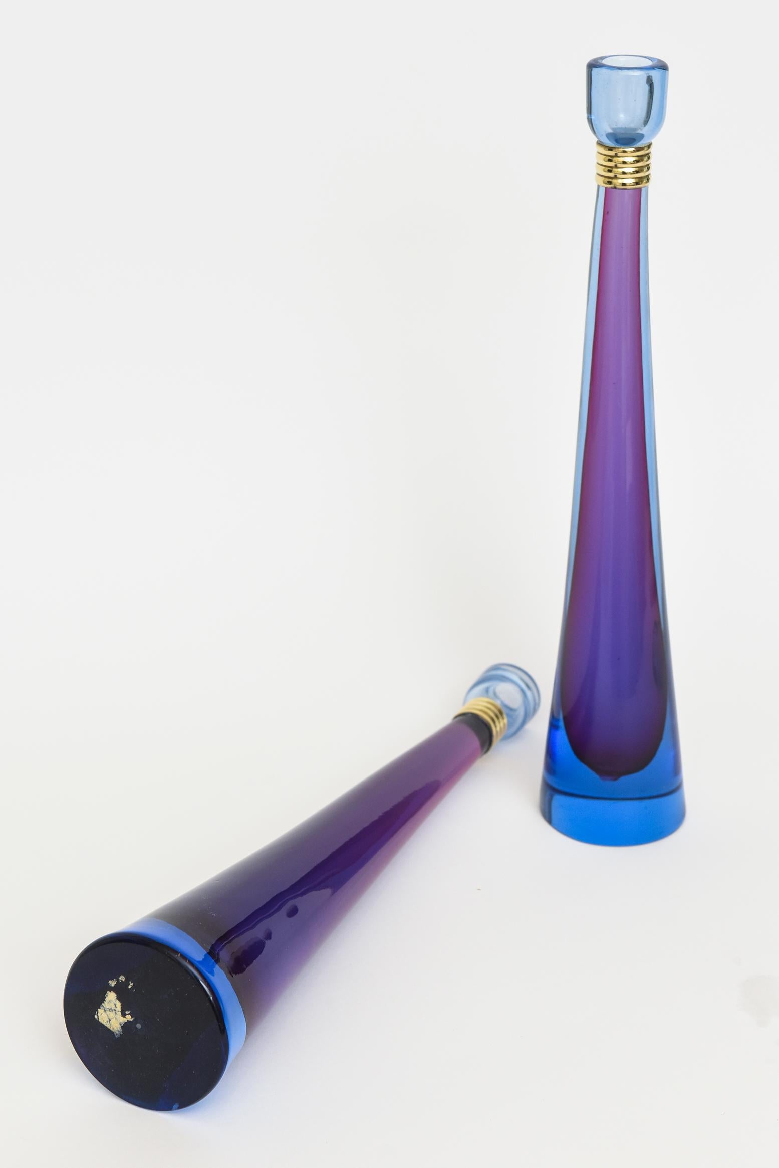 This fabulous pair of stunning vintage Italian Murano glass candlesticks are a gorgeous combination of purple and blue hues in sommerso form. These are midcentury Modern and have a now polished brass banding before the top. From the 1950s. One is