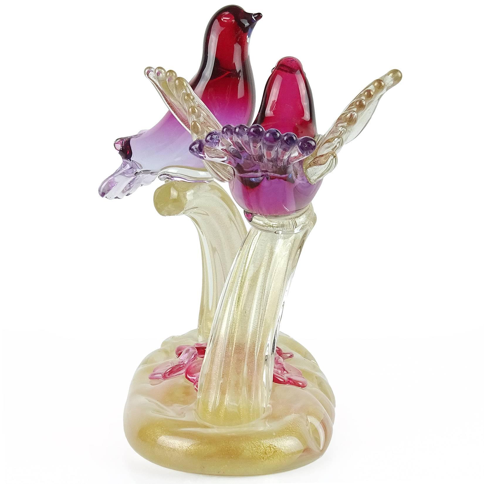 Gorgeous Murano hand blown Sommerso cranberry red to purple and gold flecks art glass courting birds sculpture. Documented to designer Alfredo Barbini. The piece is profusely covered in gold leaf, with 6 flowers on the base. Measures 7 1/4” tall x 6