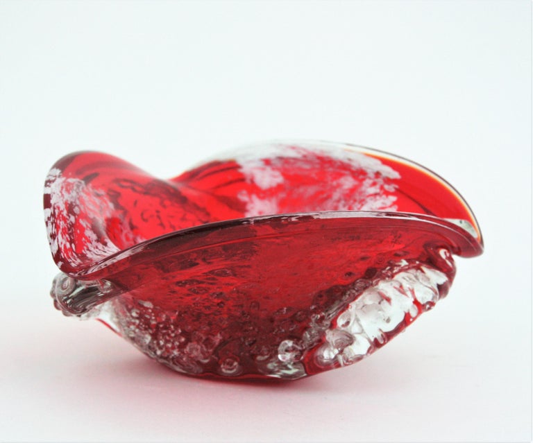 Hand blown Macette Murano glass ashtray, red, white and clear glass, Italy, 1950s.
This eye-catching triangular bowl is made with red glass submerged into clear glass. It has accents in white and the outer surface is finished using the 'macette'