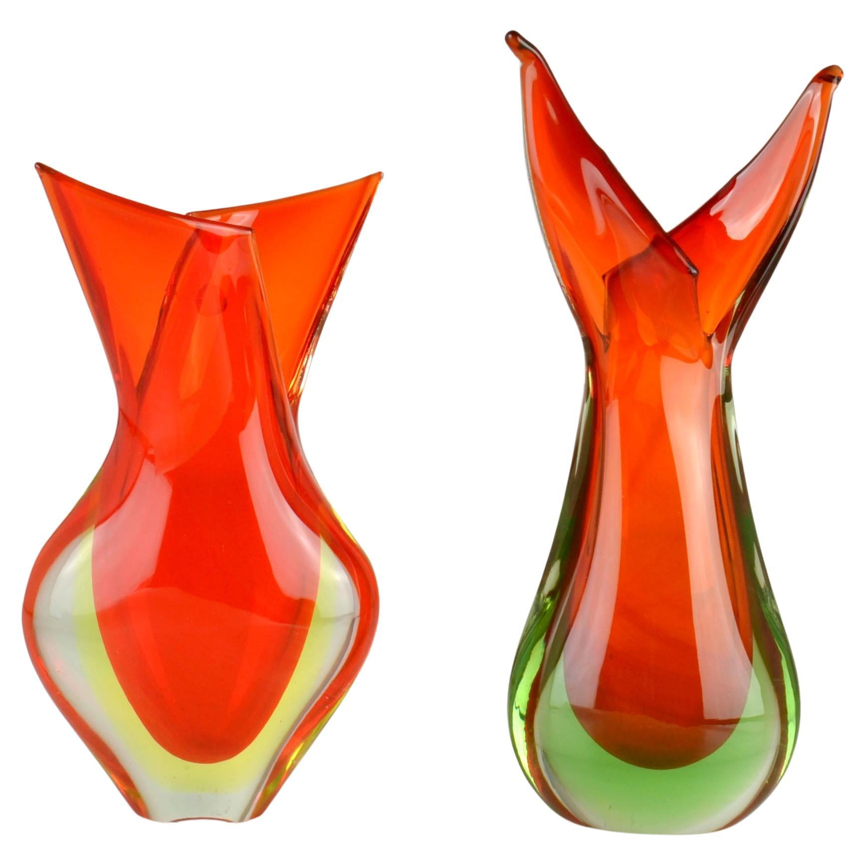 Glass vases by Flavio Poli for Seguso 1950s in fiery orange shaped like a flame.They are hand blown, known as Venetian Sommerso, made in Murano, Venice, Italy. 
The vases are a combination of orange overflowing into yellow or green glass and encased