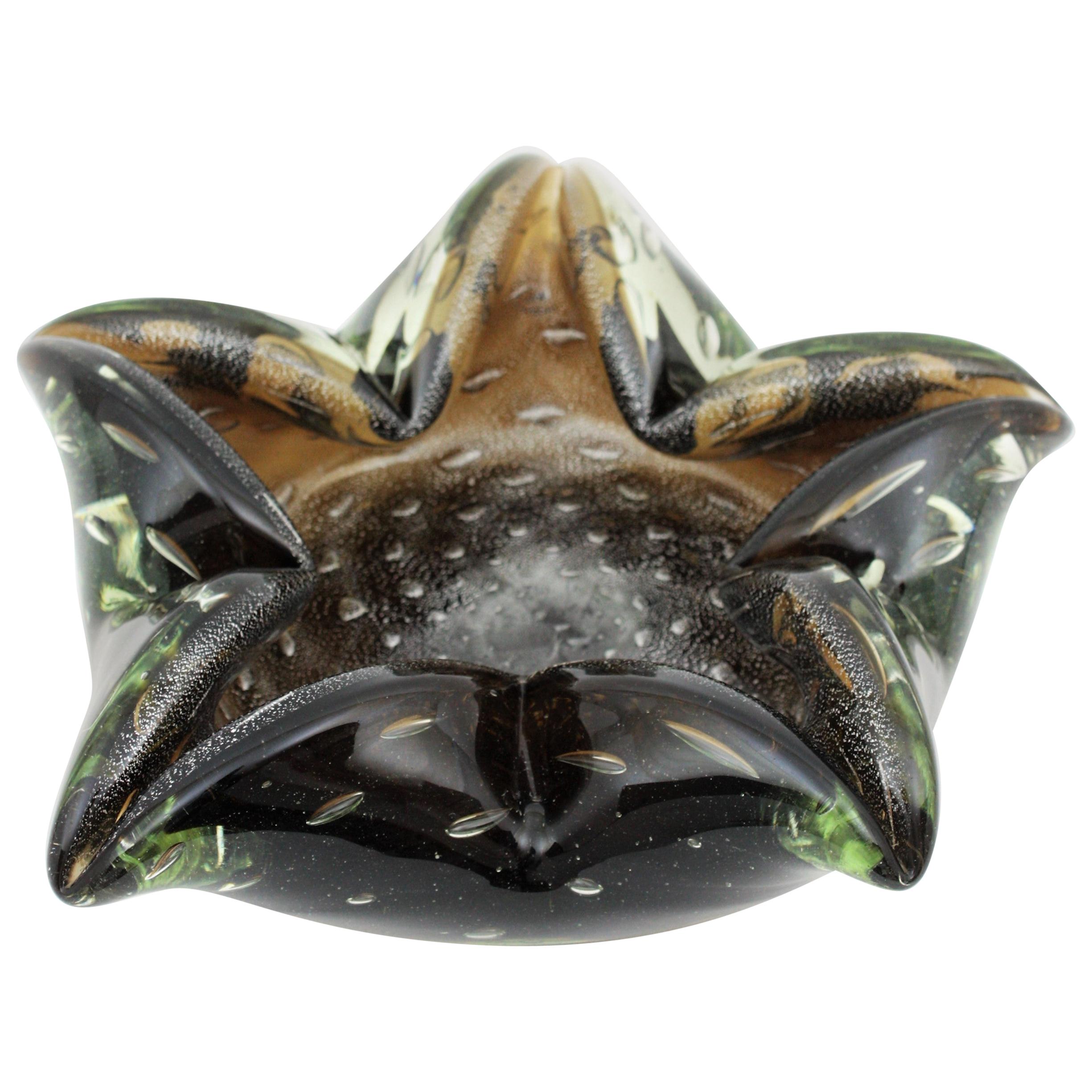 Murano smoked and clear Sommerso star shape glass bowl with silver flecks, Italy, 1950s.
Amazing 5-pointed star shaped hand blown Murano art glass bowl or ashtray made of smoked amber/brown glass cased into clear green glass. It has Aventurine