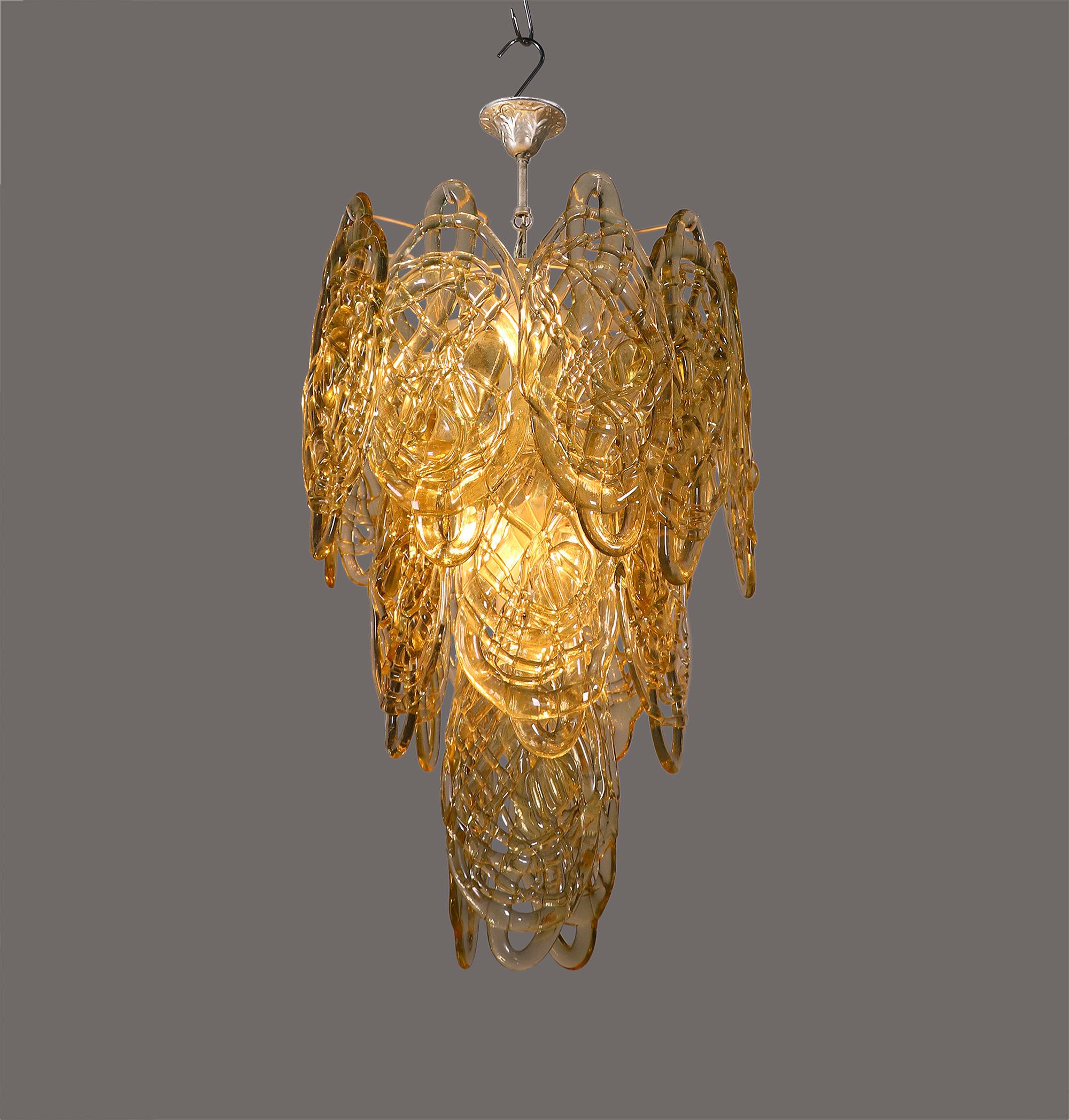 Elegant 'Spaghetti' chandelier with nineteen large mouth-blown, amber-colored wired glass panels on a white metal frame. Early execution. Lamp sockets are made from ceramics and metal. The white frame got at several points after-lacquered.