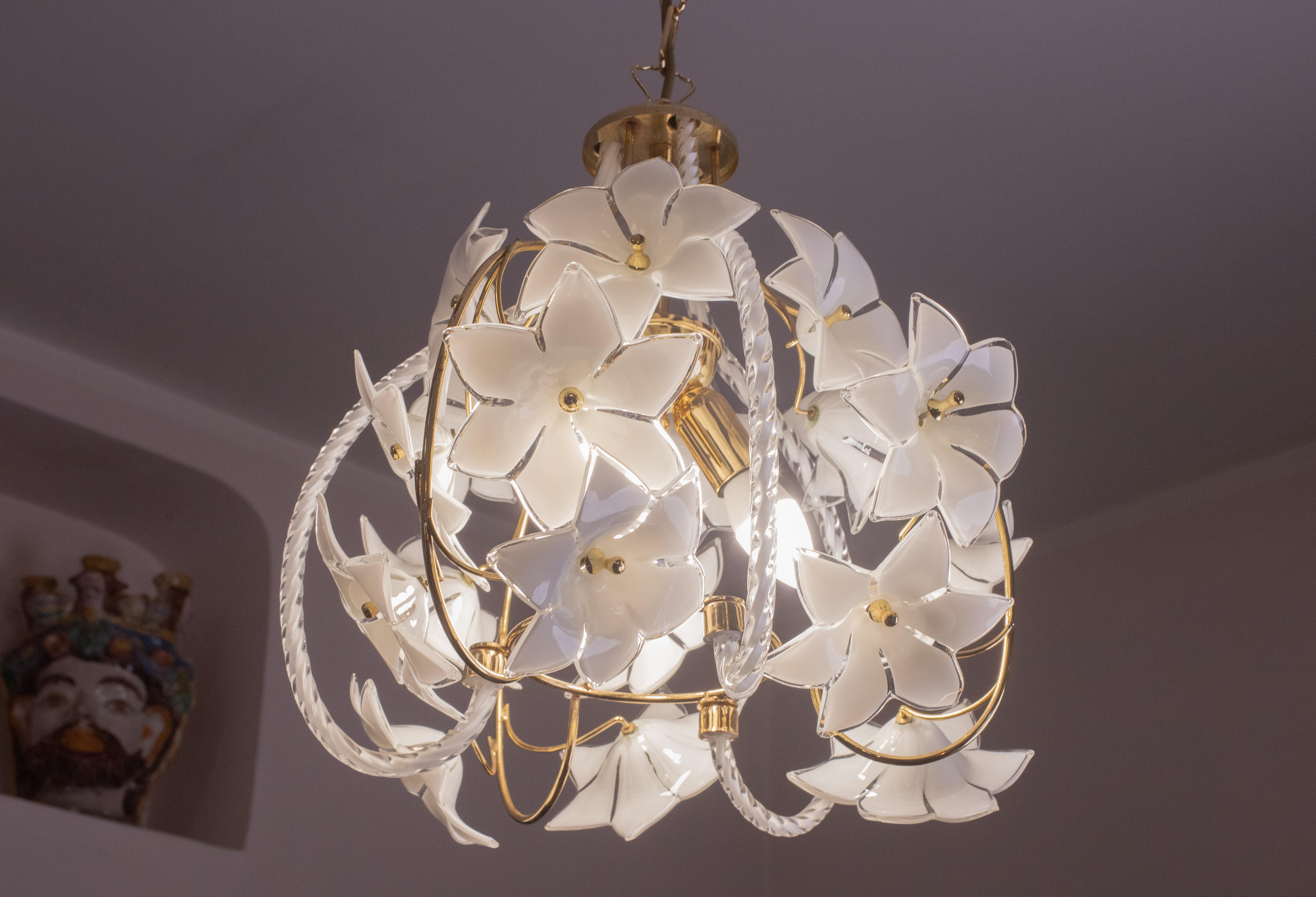 Vintage Murano glass chandelier filled with white flowers.
The structure of the chandelier is circular and has three beautiful glass elements around the circumference.
The chandelier has 3 light points with E14 socket.
The frame is in gold bath, in