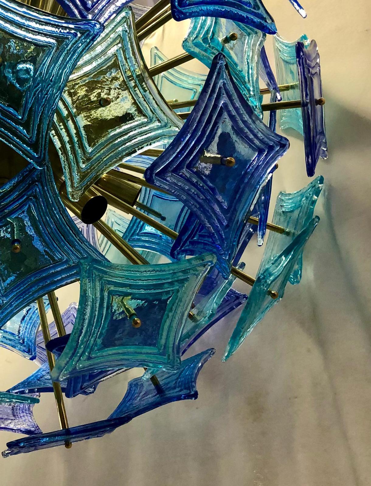 De grands et particuliers mouchoirs en verre, comme s'ils étaient des losanges, composent ce beau lustre de Murano, plus avec deux couleurs vives et originales : le vert clair et le bleu.

Constitué d'une grande sphère centrale dans laquelle sont