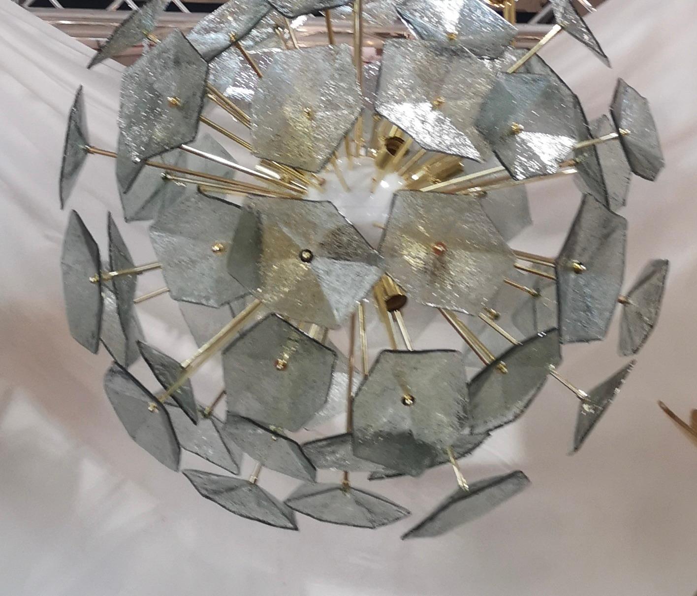 De grandes fleurs en verre composent ce magnifique lustre de Murano. Un Sputnik classique du milieu du siècle.

Composée d'une grande sphère centrale dans laquelle sont vissées des tiges de laiton, des feuilles de verre sont positionnées au-dessus