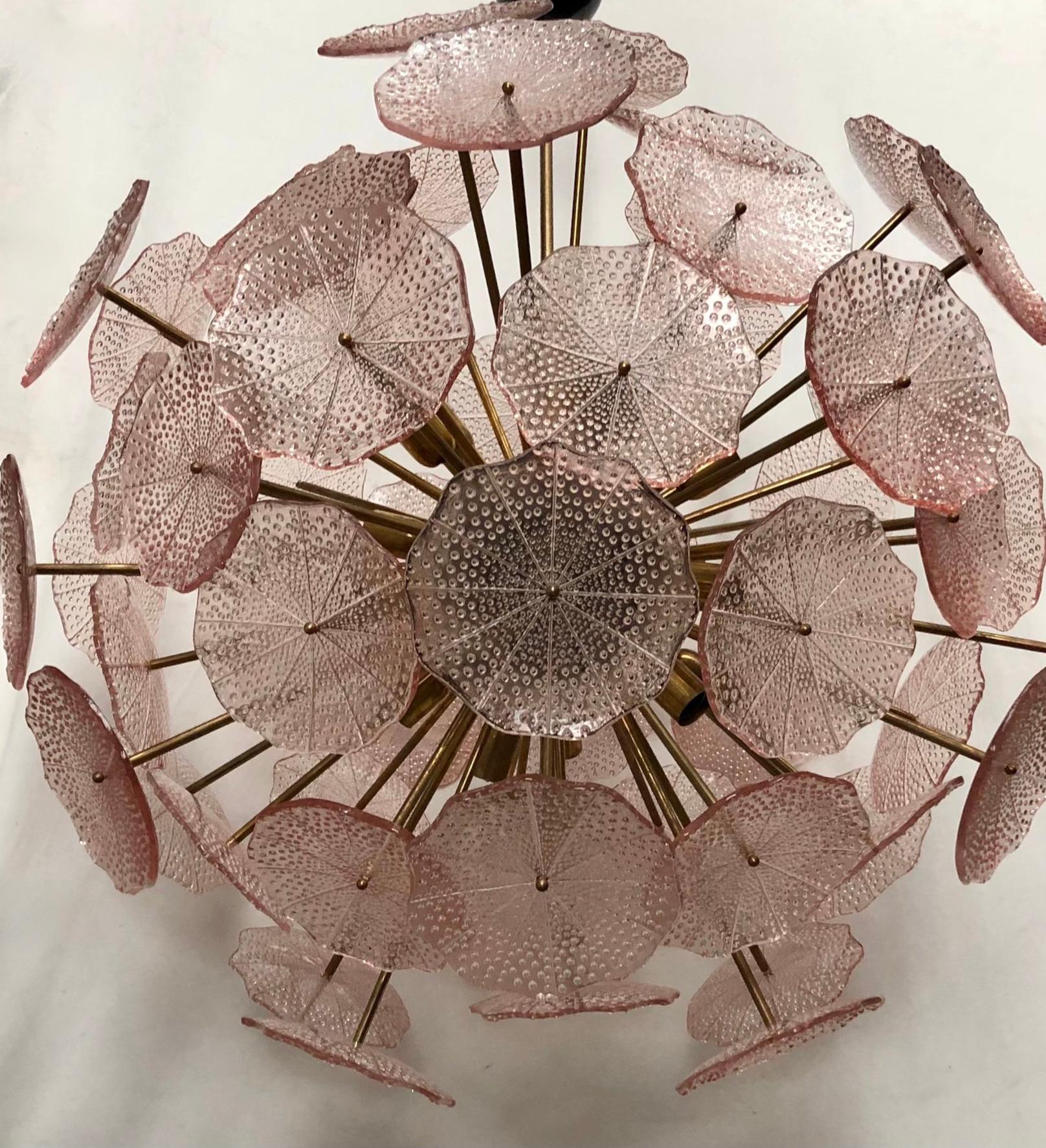 The large glass flowers make up this Murano chandelier from the 1980. A Classic Sputnik from the middle of the century.

Made of a large central sphere in which brass rods are screwed, glass leaves are placed above the brass rods. It has 18-light