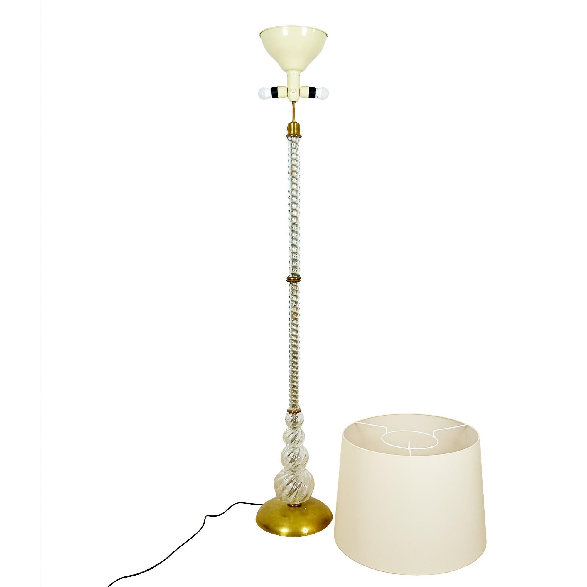 Lámpara de pie de cristal grueso soplado de Murano y latón pulido. Tres puntos de luz. Pantalla renovada en tejido marfil.

Italia hacia 1940
