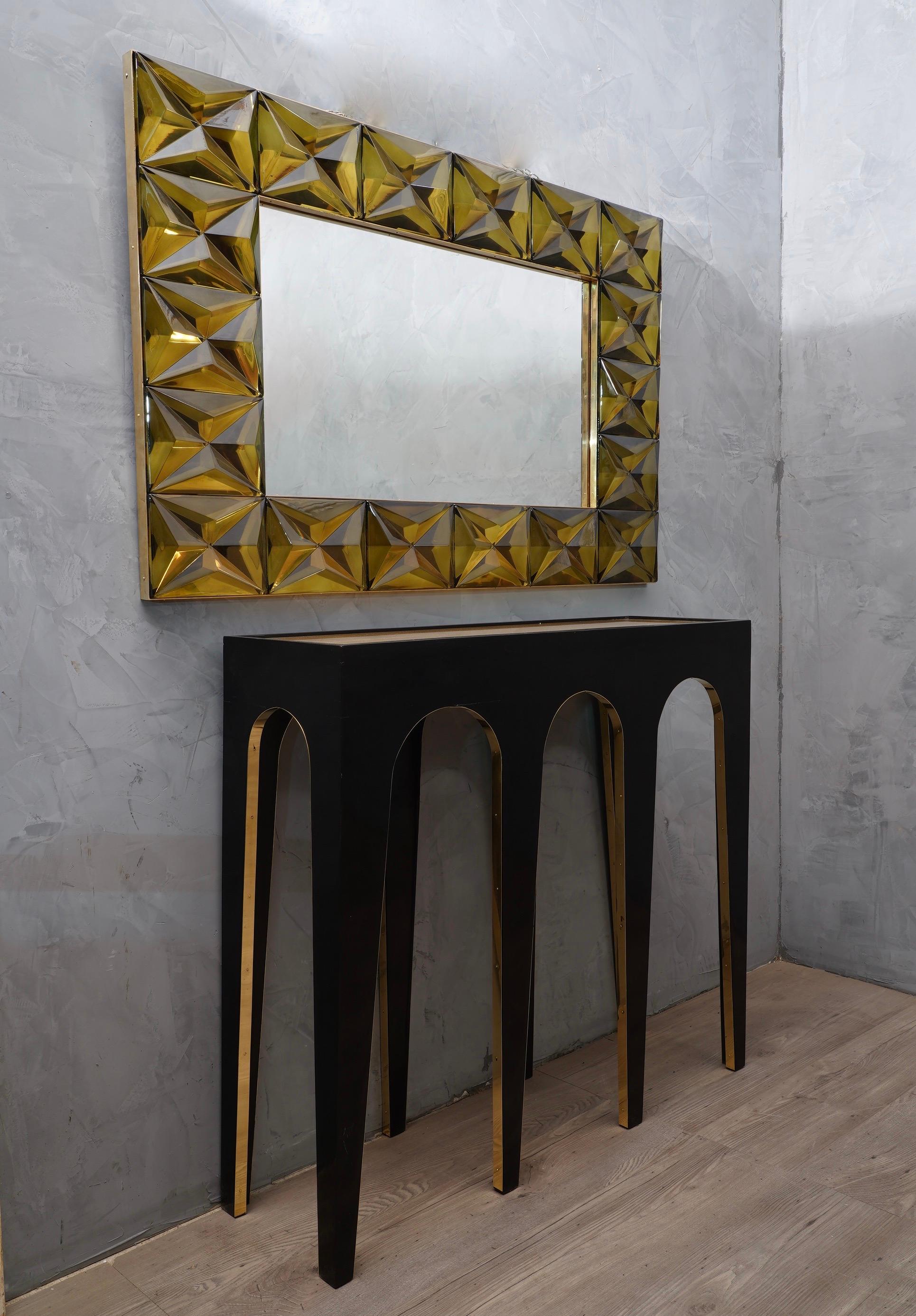 A strong olive green frame reach the eye of the beholder leaving him entranced; of Murano green art glass wall mirror. 

The structure of the wall mirror is in wood, where the olive green Murano glass is housed. The frame of the mirror is made up of
