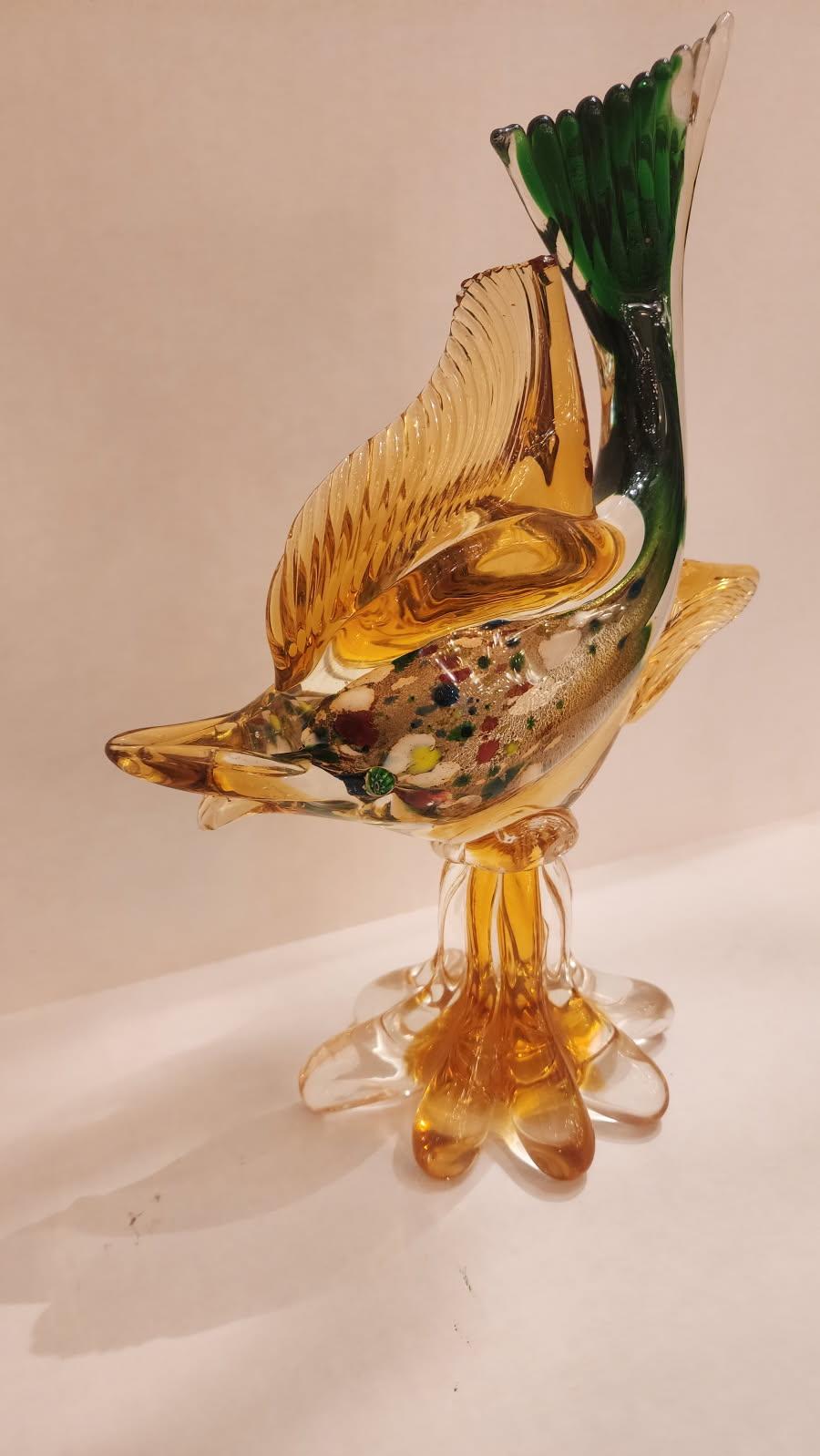 Cette annonce présente une magnifique sculpture de poisson en verre de Murano de couleur orange. Ce poisson a une queue verte, un corps orange transparent et des taches vertes.

L'origine du verre de Murano remonte au VIe siècle ADS, l'île de Murano