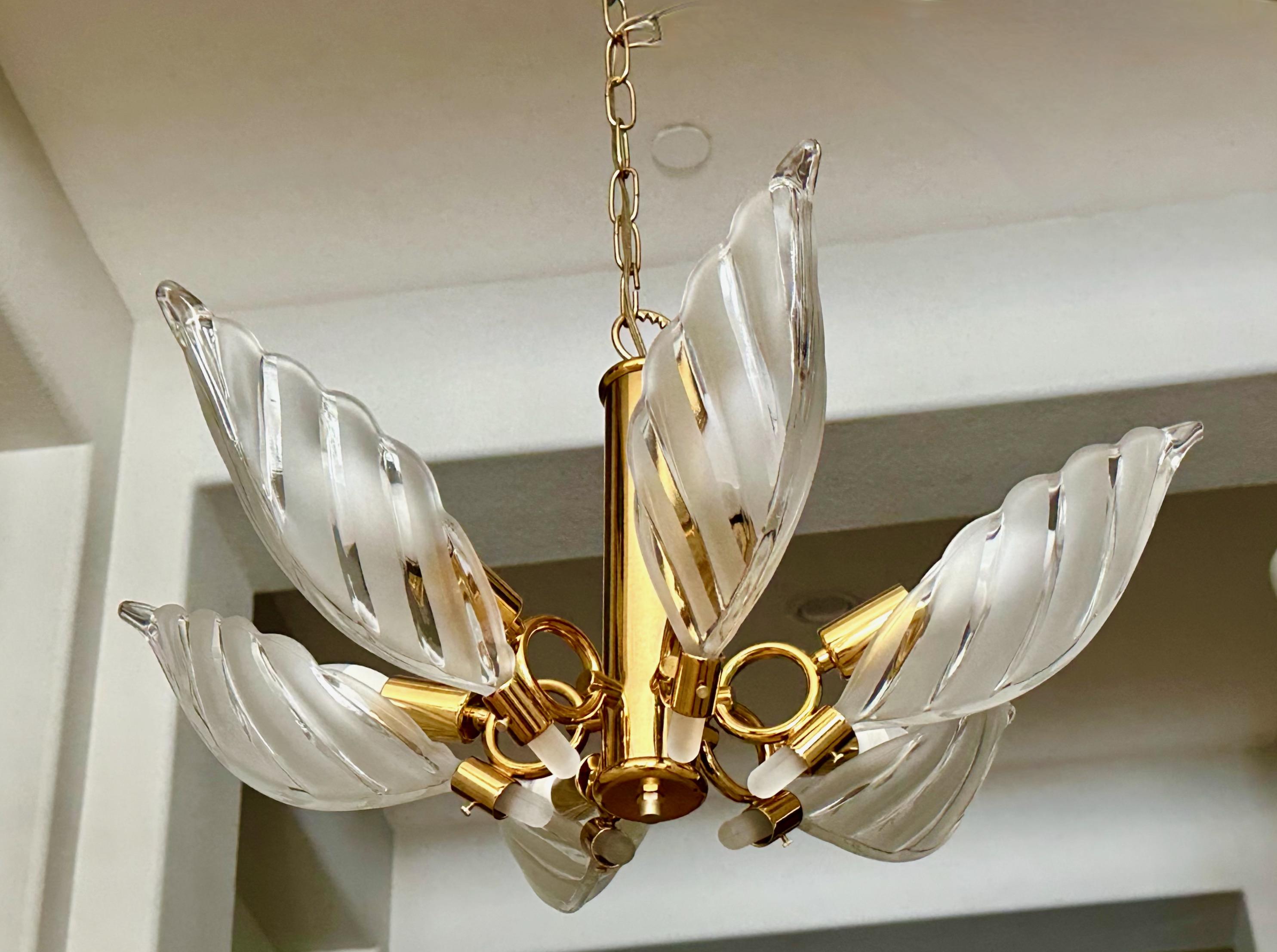 A leaf shaped chandelier (or ceiling pendant) mounted on a plated gold brass frame, in the style of Murano. Features 6 striped etched frosted and clear shaped press glass leaves, along with 6 lights-- each uses single candelabra size bulb. Overall