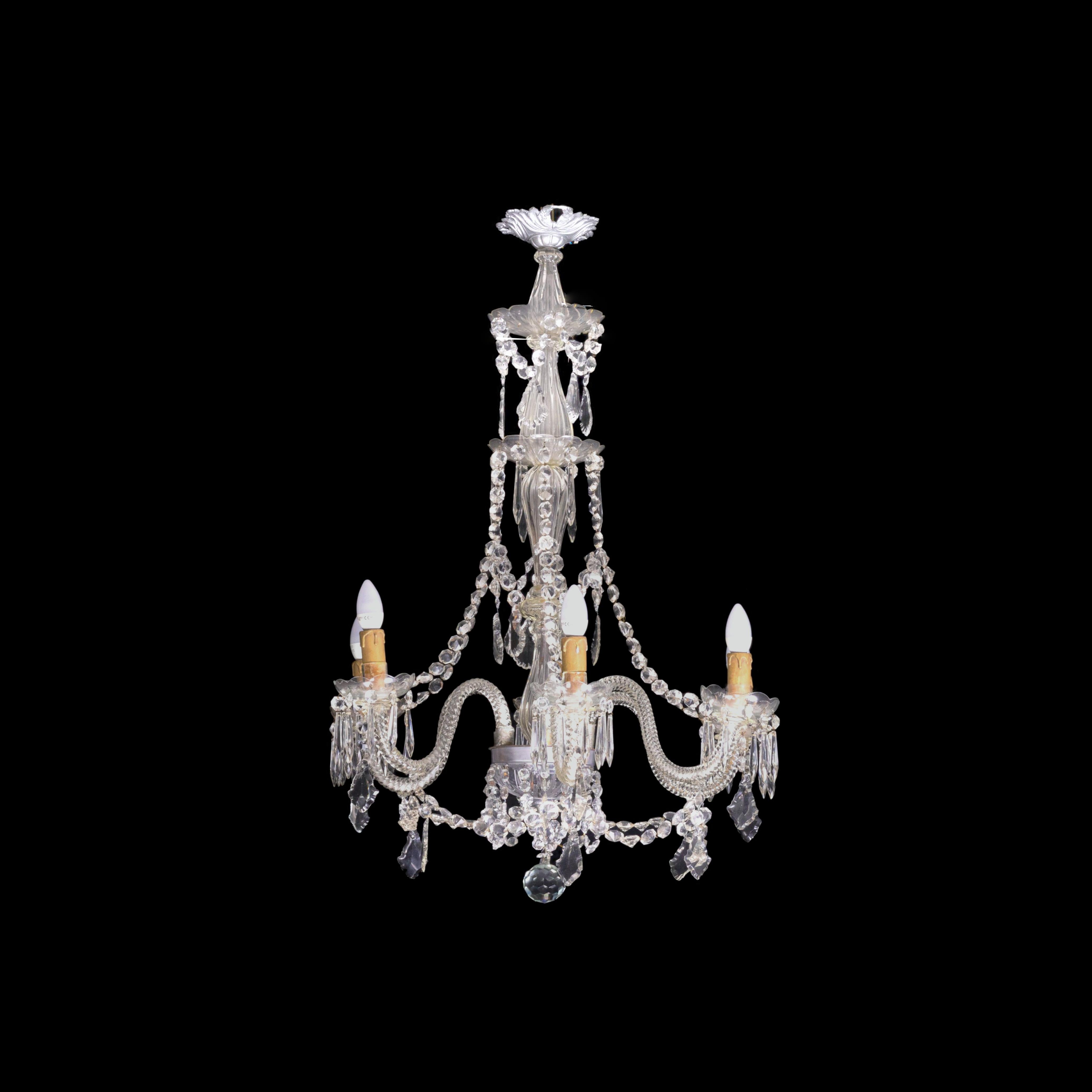 This exquisite chandelier lamp showcases the elegance of Murano style with its six arms, bronze structure, and stunning crystals and pendant glass. It has been recently reviewed and is in perfect working condition. Rest assured, the lamp will be