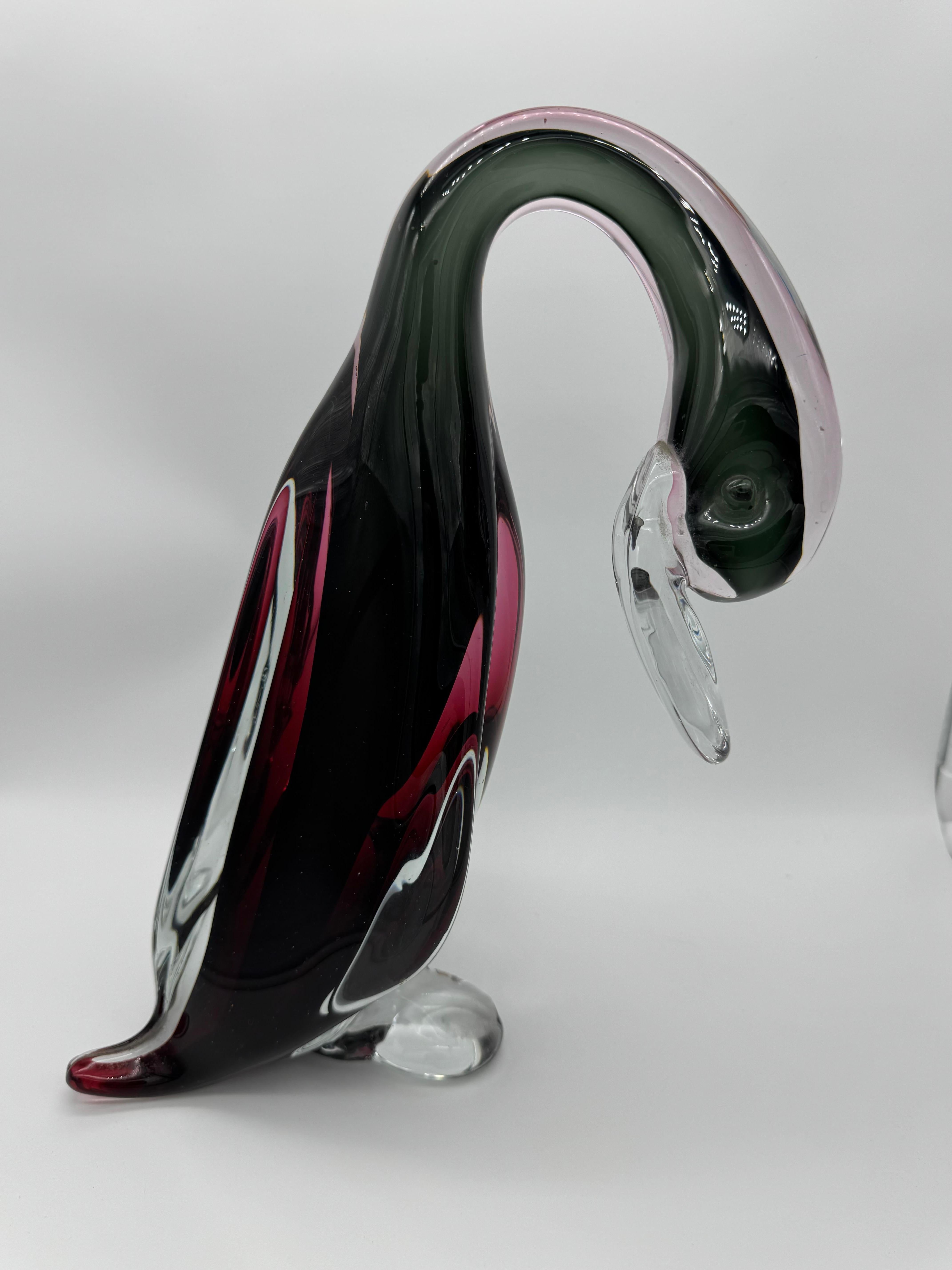 * Attribué à Archimede Seguso : ce cygne reflète le style distinctif et le savoir-faire du célèbre artiste du verre de Murano.
 * Combinaisons de couleurs magistrales : Le verre foncé et profond contraste magnifiquement avec les tons rouge vif et