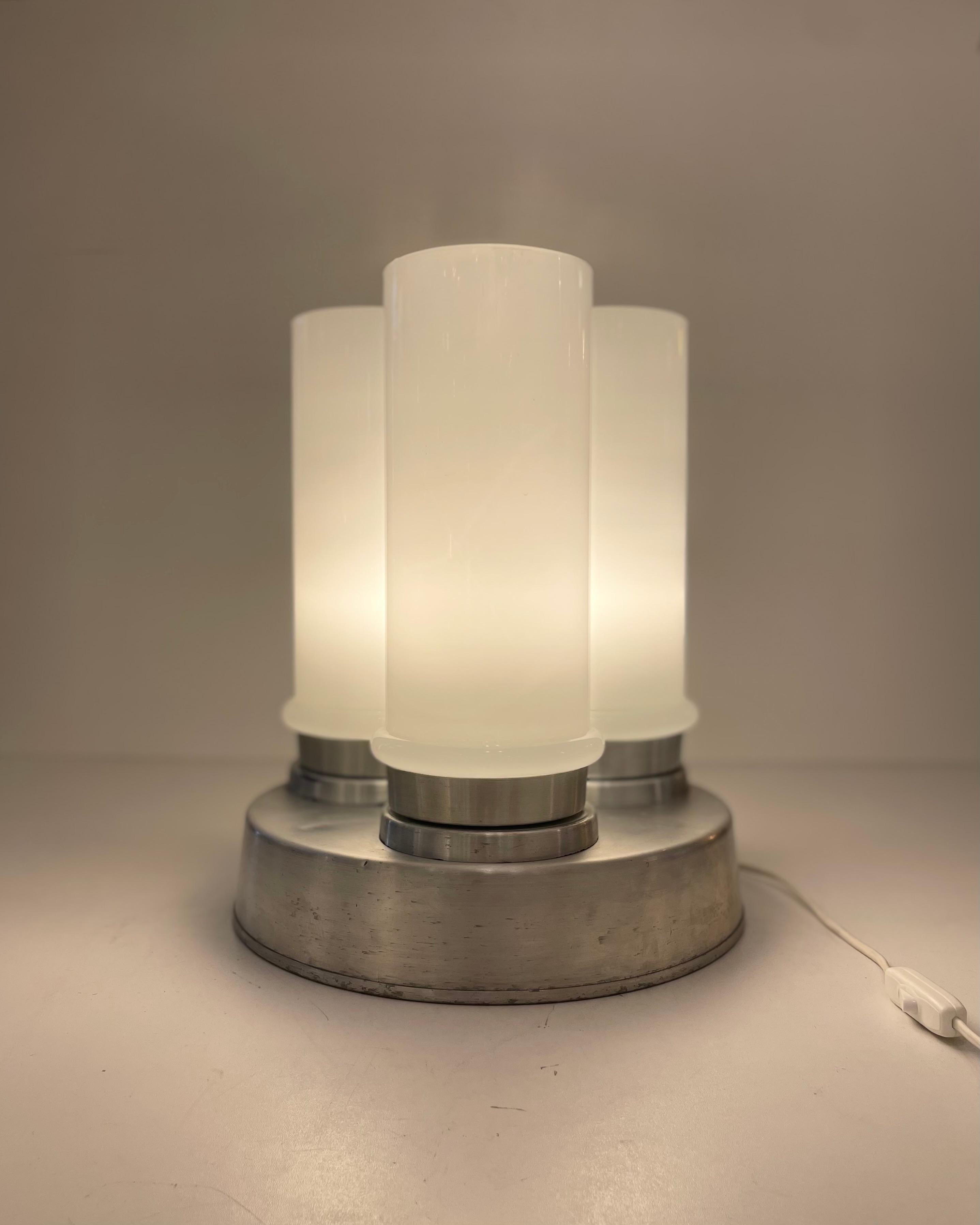 Italian table lamp made of three opaline Murano glass tubes on a stainless steel round base, designed in Murano in the 1960’s.
-
Lampe de table italienne composée de trois tubes en verre opalin de Murano sur une base ronde en acier inoxydable,