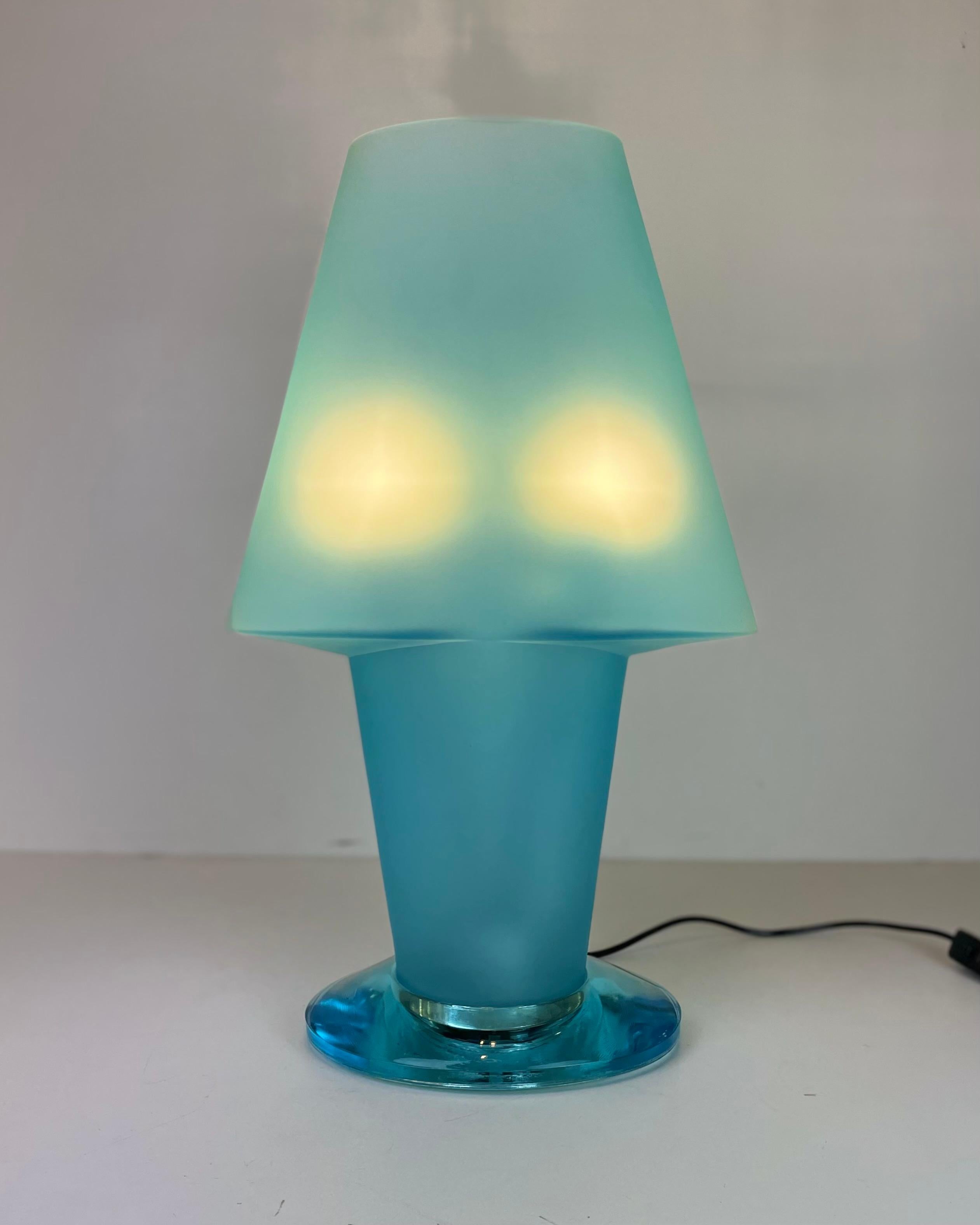 Grande lampe de table italienne réalisée à partir d'une seule pièce de verre bleu dépoli de Murano, posée sur un bloc de verre bleu transparent de Murano, sous une feuille de métal qui donne de la profondeur à l'ensemble. Conçu dans le style de