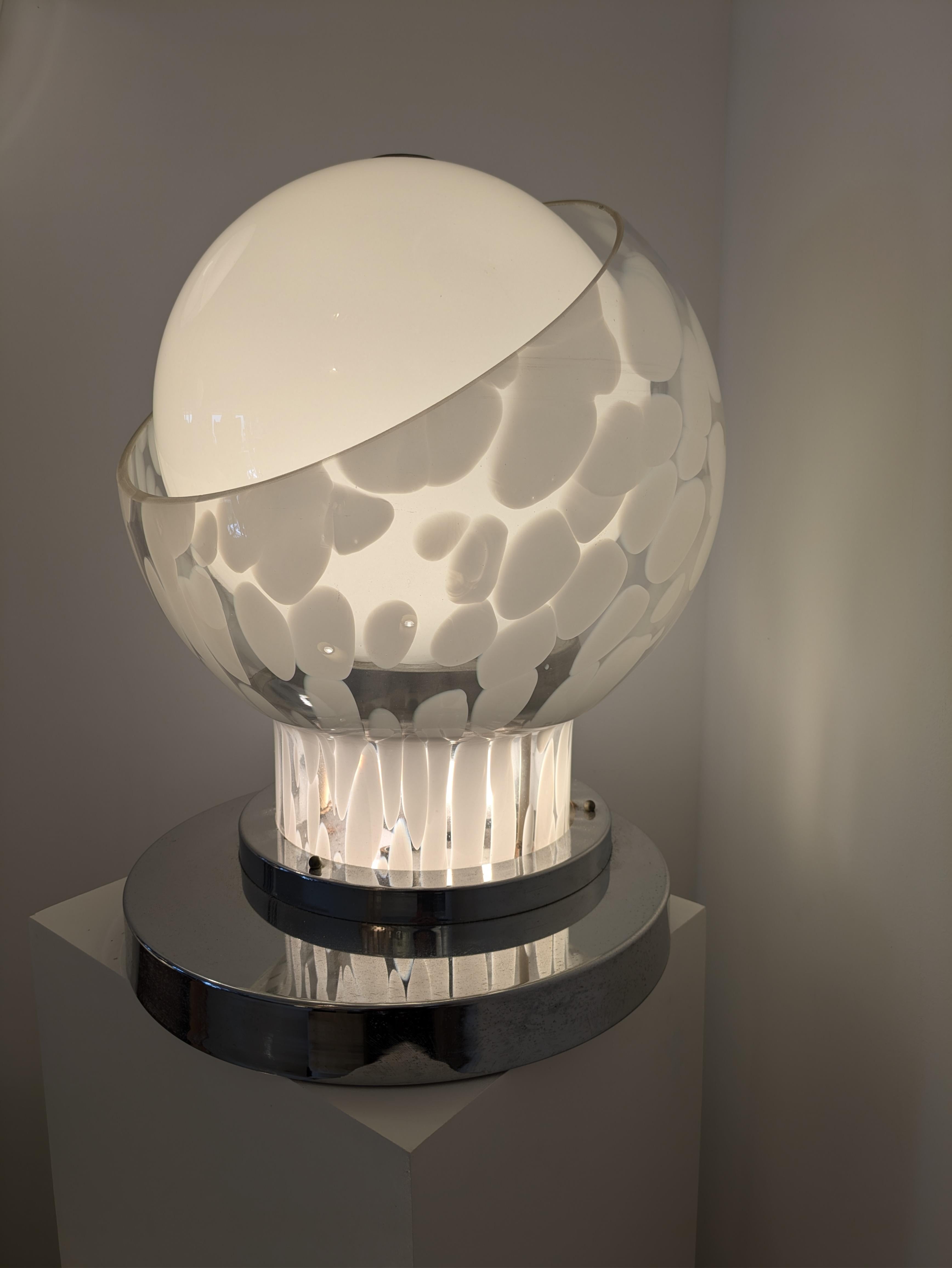 This rare and Iconic table lamp has been designed by Angelo Brotto and edited by Esperia in the early 1970.

It is composed of two pieces of glass. First the white opaline globe is inserted in a long neck 