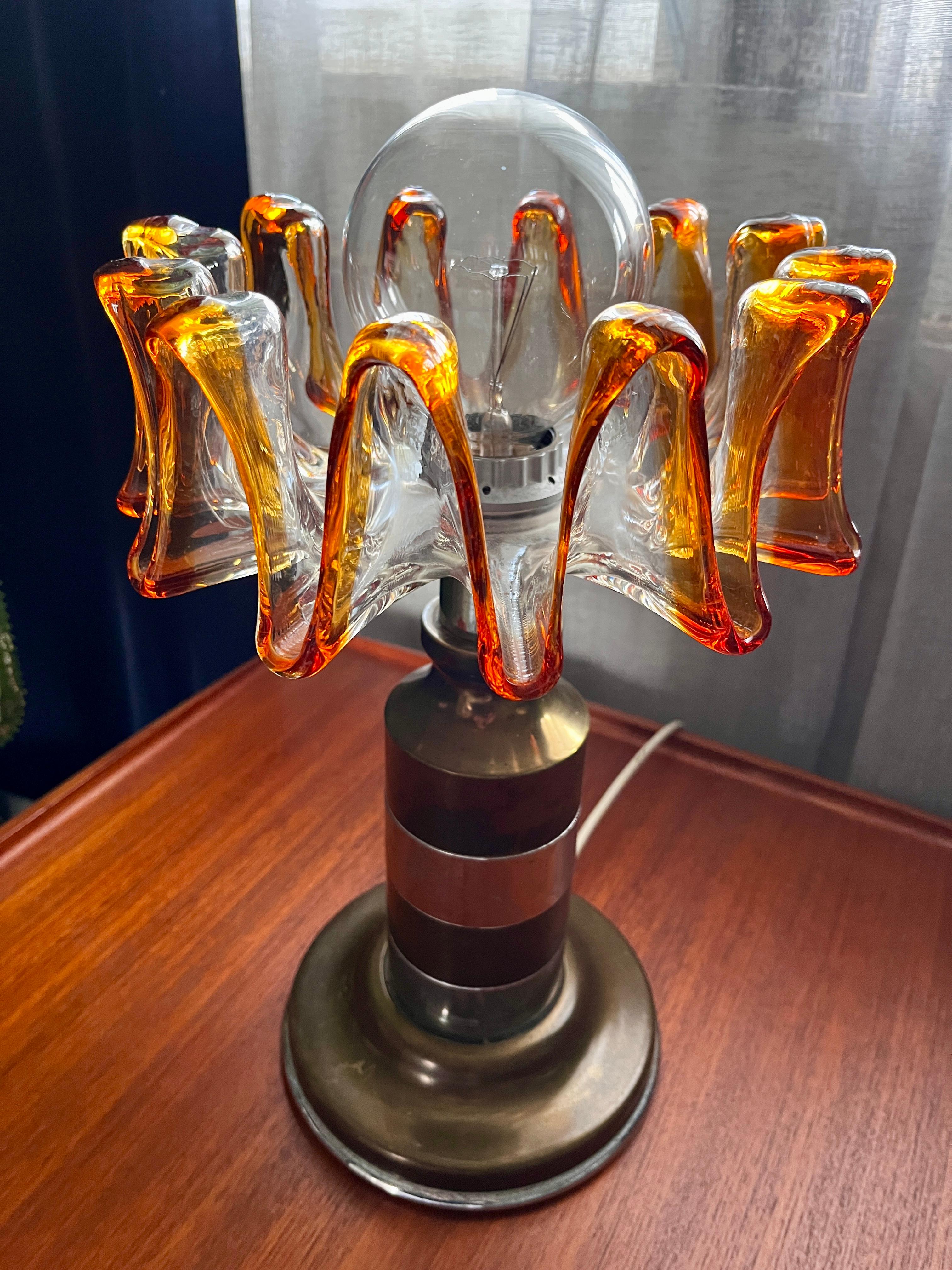 Grosse Vintage Tischlampe von Toni Zuccheri für Mazzega aus den 70s.
Der Glasschirm mit ihrem dünnen und transparent bis braun-orangenem Glas, wirft tolle Reflexionen in den Raum.

Durchmesser der Schirme 27 cm
Durchmesser vom Sockel 20 cm
Höhe 39