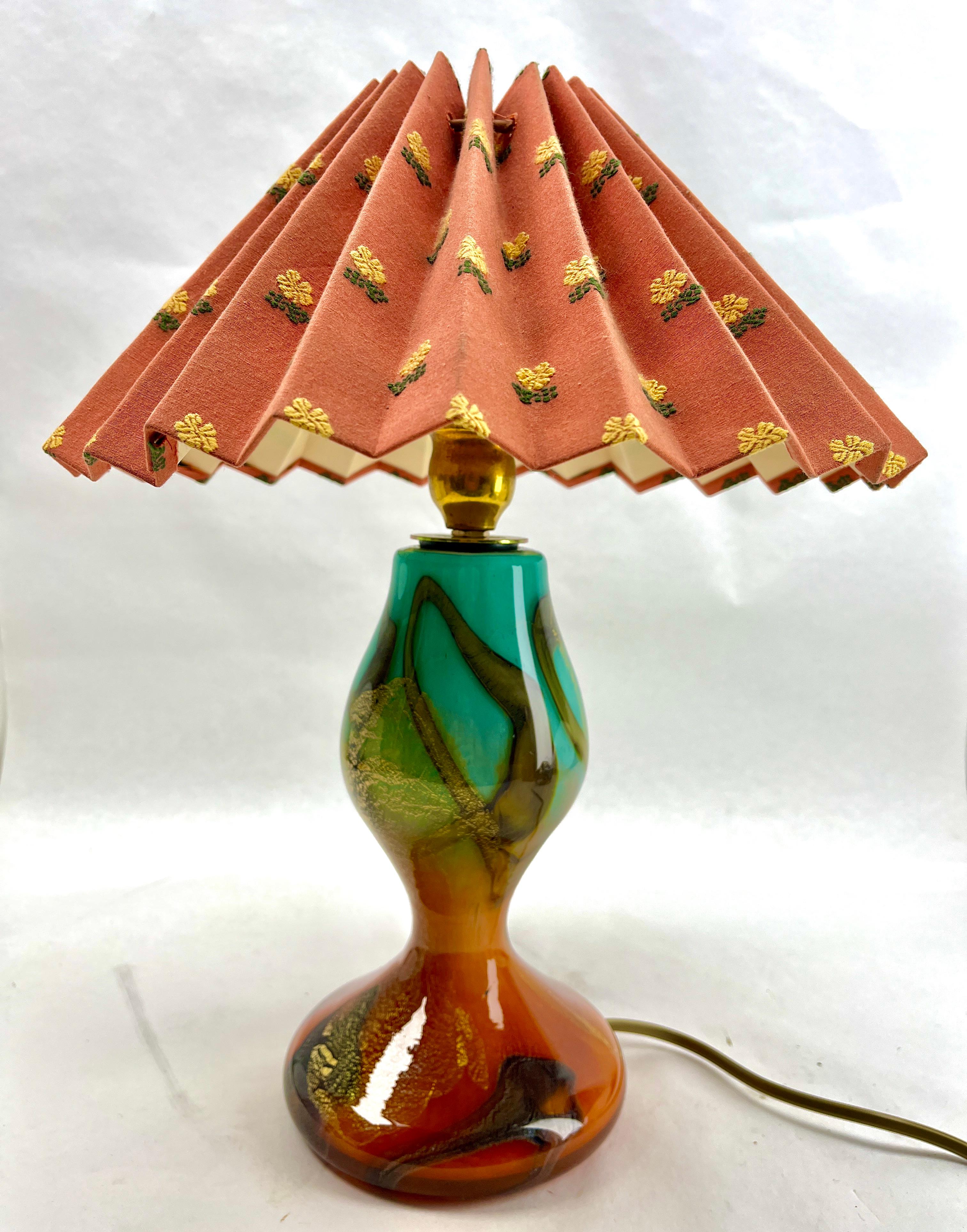 This Art Nouveau-style table lamp was designed and manufactured in Italy during the 1960s. 
The base is in colored blown glass and Gold Flecks details. 
It is in good original and period condition.