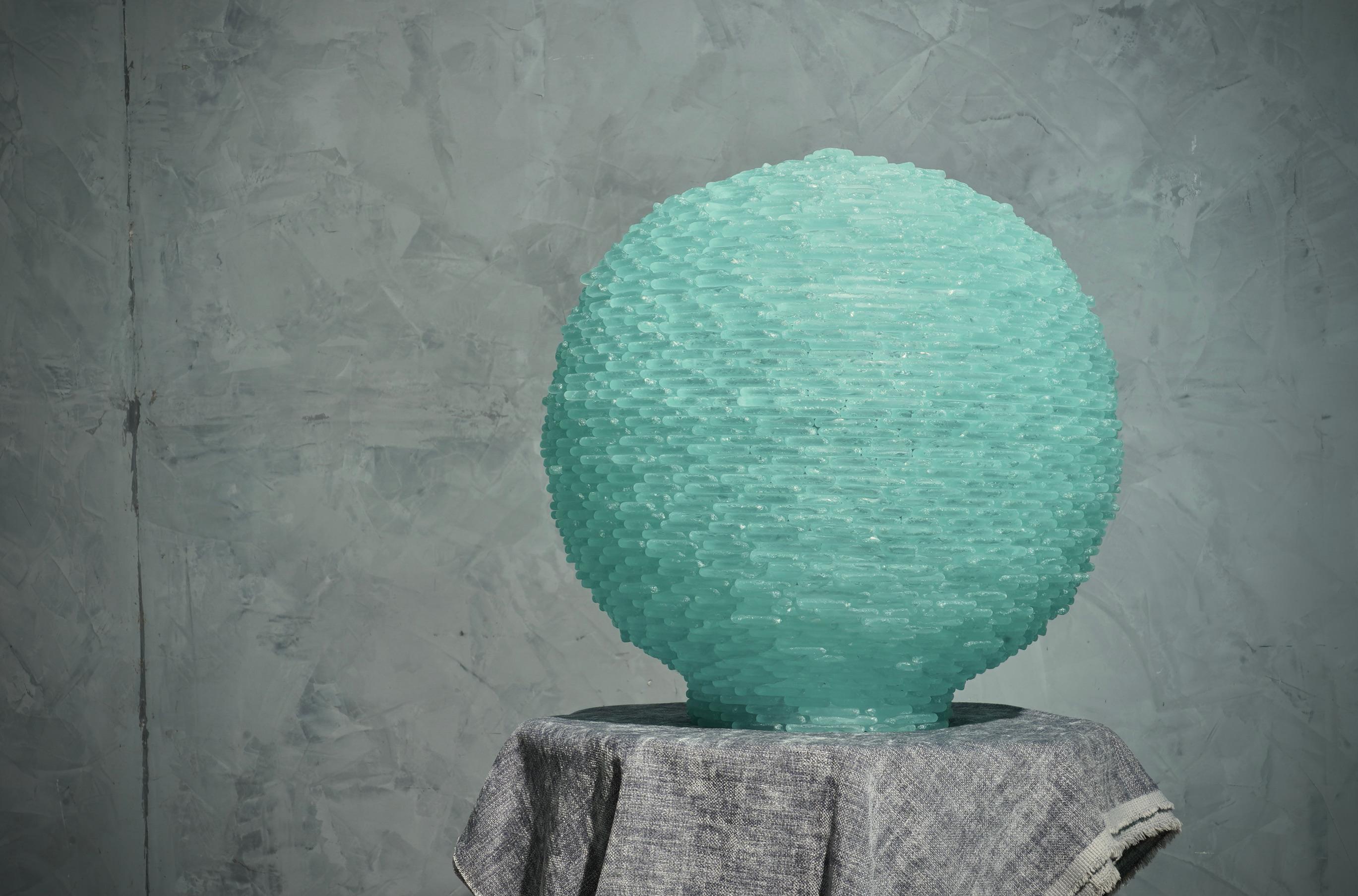 Splendid terrestrial globe all in satin-finished Murano glass stones, beautiful aqua green color.

The globe is composed of two superimposed semi-spheres, formed by an infinite series of small plates in Murano glass. Internally there are lights that