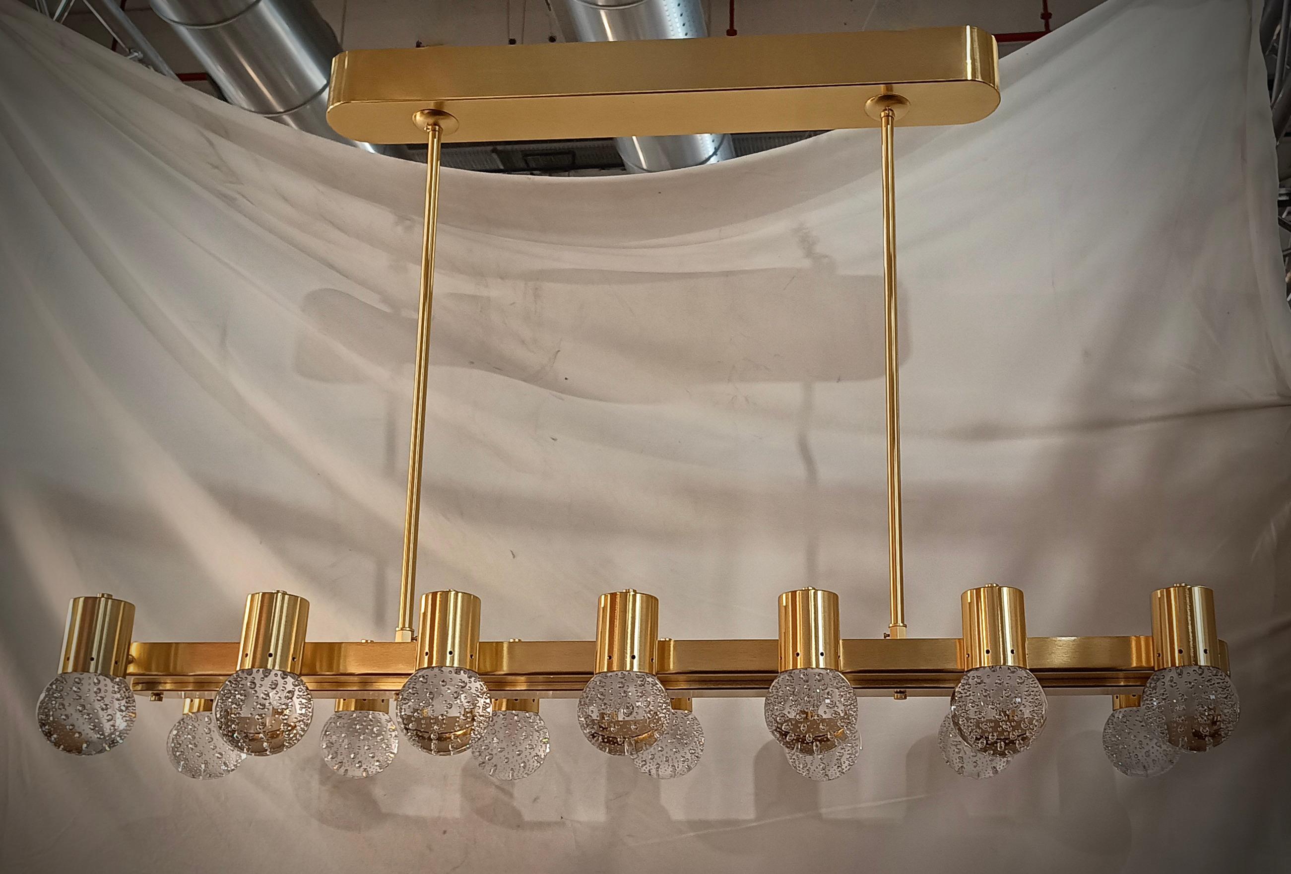 Murano chandelier with an elongated design with a brass structure and single transparent pulegoso glass. Elegant and refined finish both for the multi-color and for the design.

The chandelier is made up of a rectangular satin brass structure, on