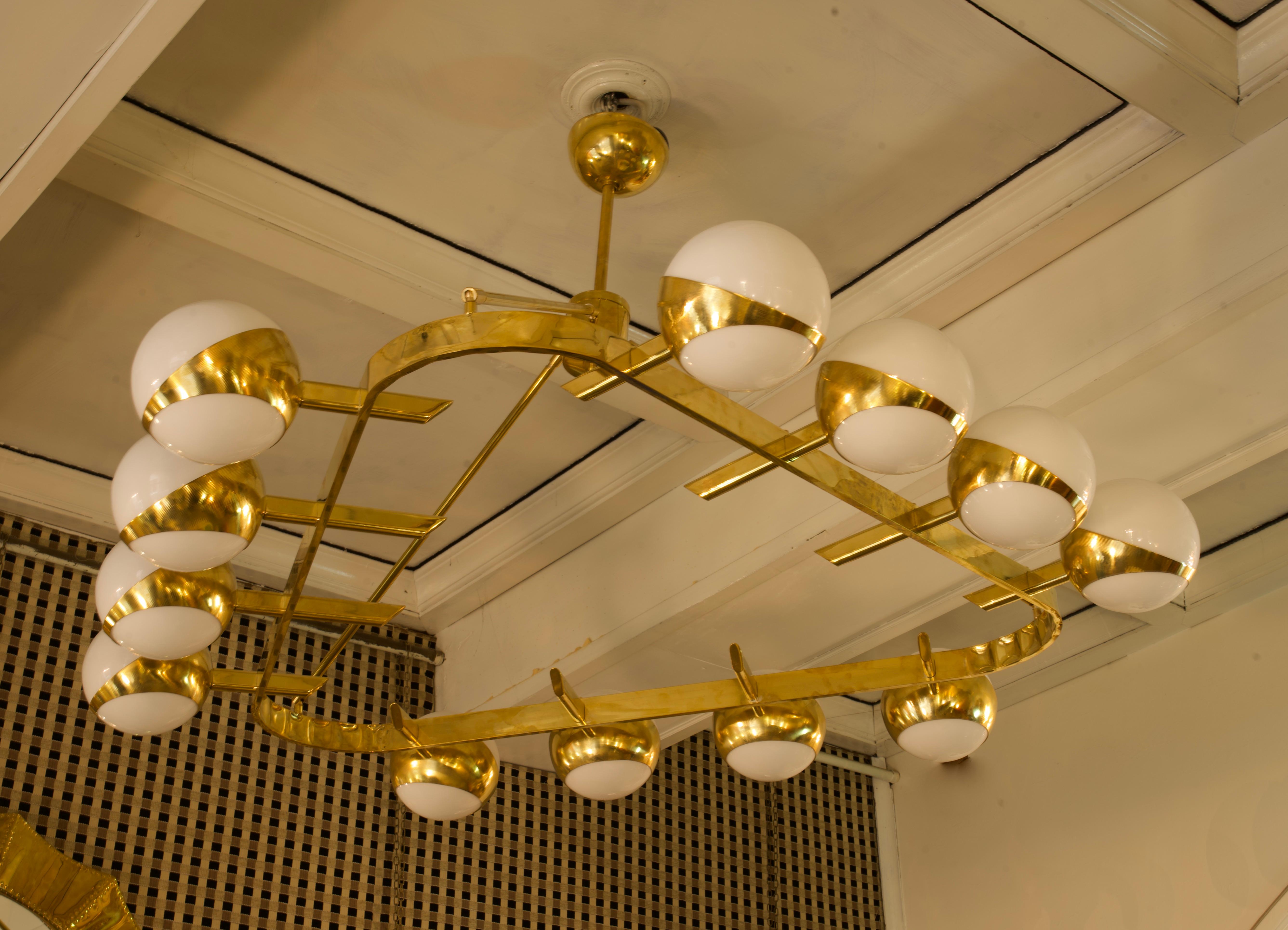 Stunning chandelier for its characteristic triangular structure, unique design for the brass housing of the spheres. Refinement and class as in the Murano style, one-of-a-kind pieces that always remain precious.

The chandelier has a polished brass