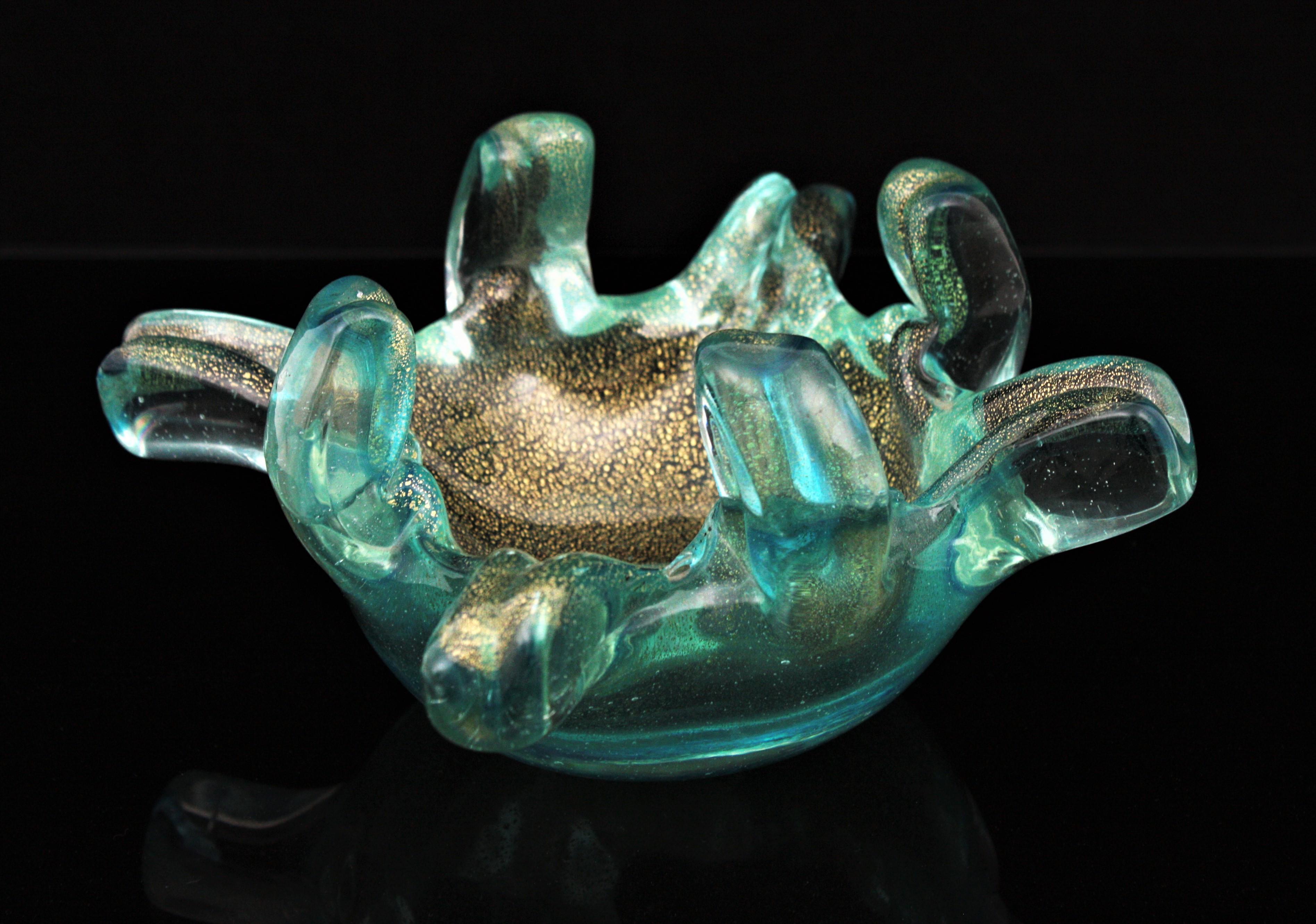 Decorative bowl or vide-poche, murano glass, gold flecks. Italy, 1950s.
Stunning Turquoise, blue and clear Sommerso Murano glass bowl with gold flecks and fingers design. 
Hanblown glass in turquoise color with a line in blue, summerged into clear