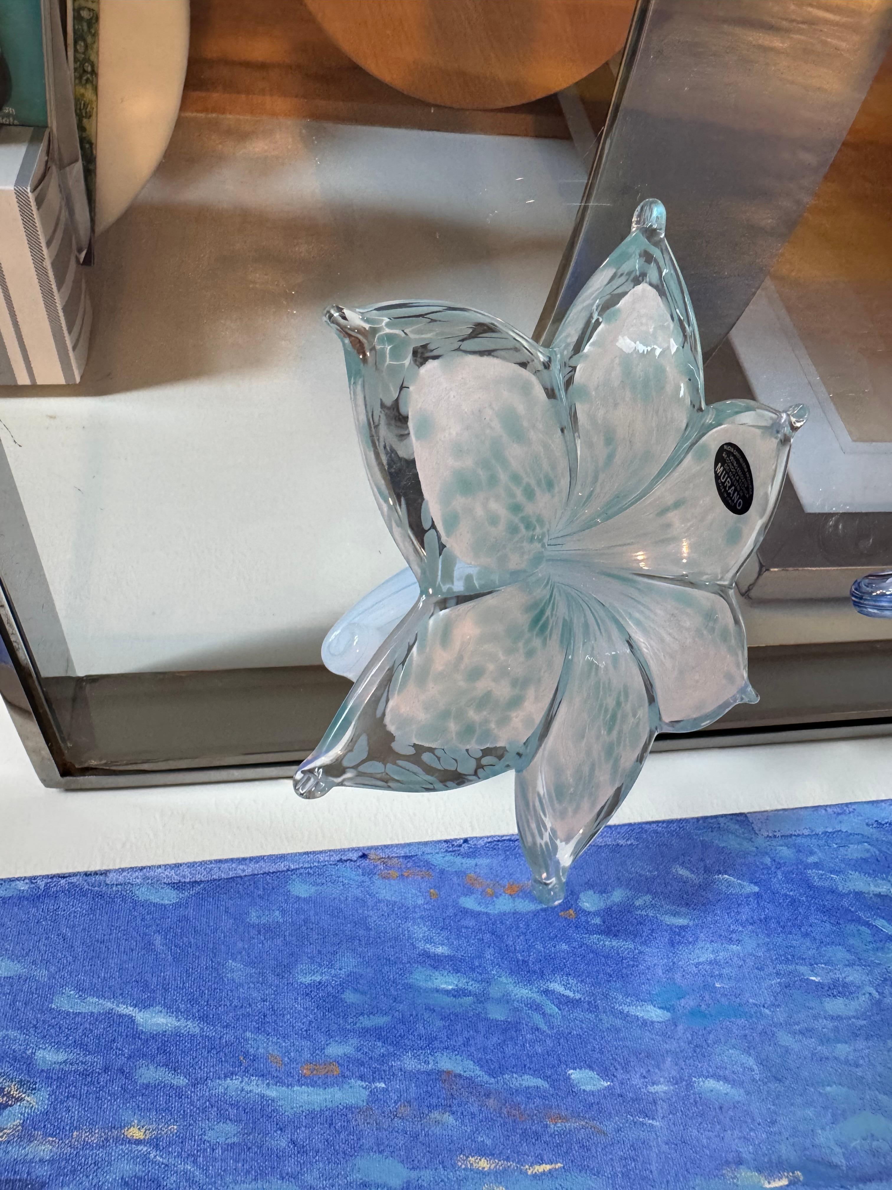 This flower is handblown.
It was crafted in Murano, Italy. 
It has a beautiful turquoise color.

Makes for a great gift.