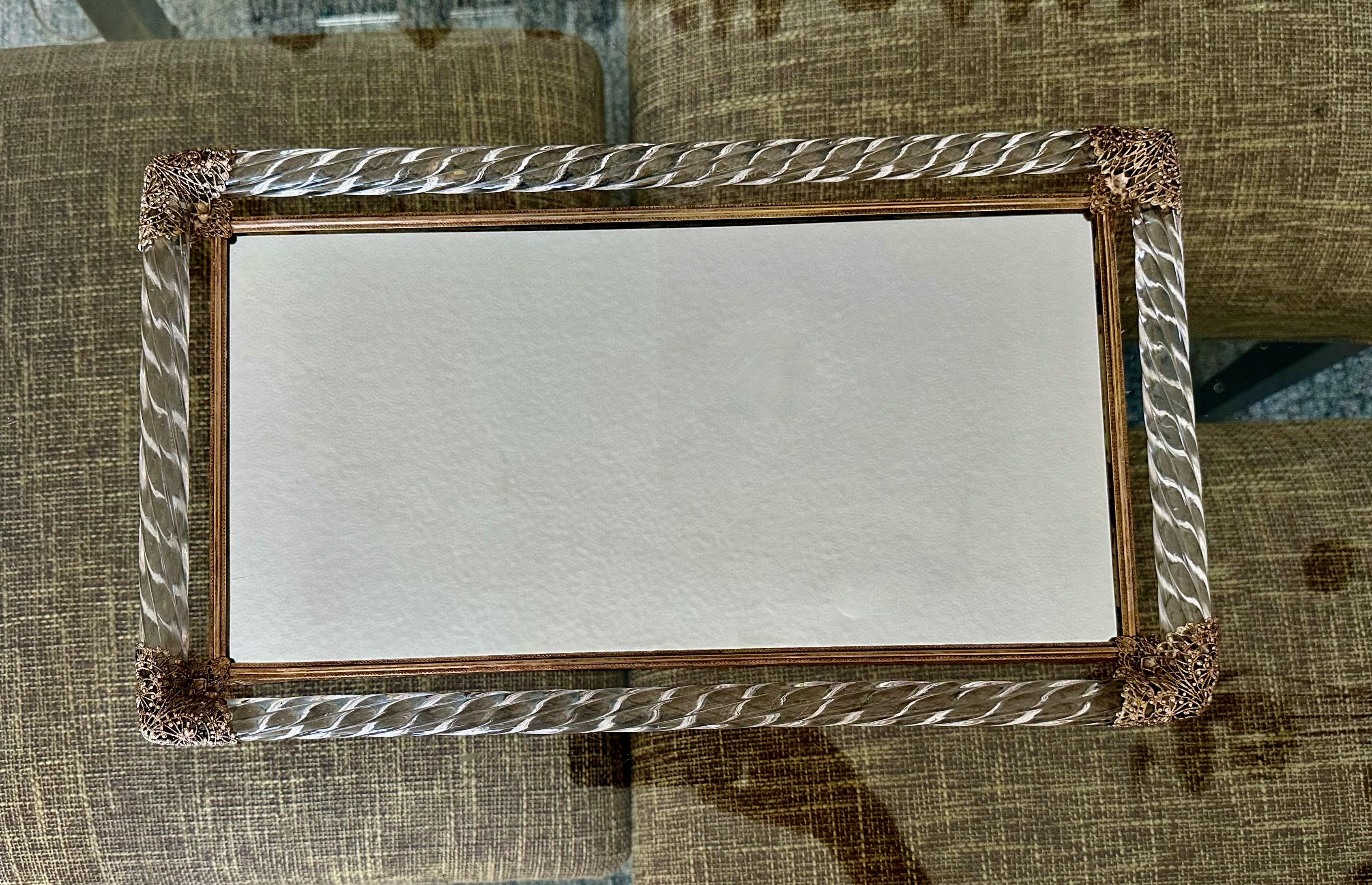 Plateau de toilette en verre vénitien de Murano surmonté d'un verre soufflé torsadé avec coins en métal filigrané ton or et côtés du cadre gaufrés ton or. 
L'insert du miroir est neuf.
