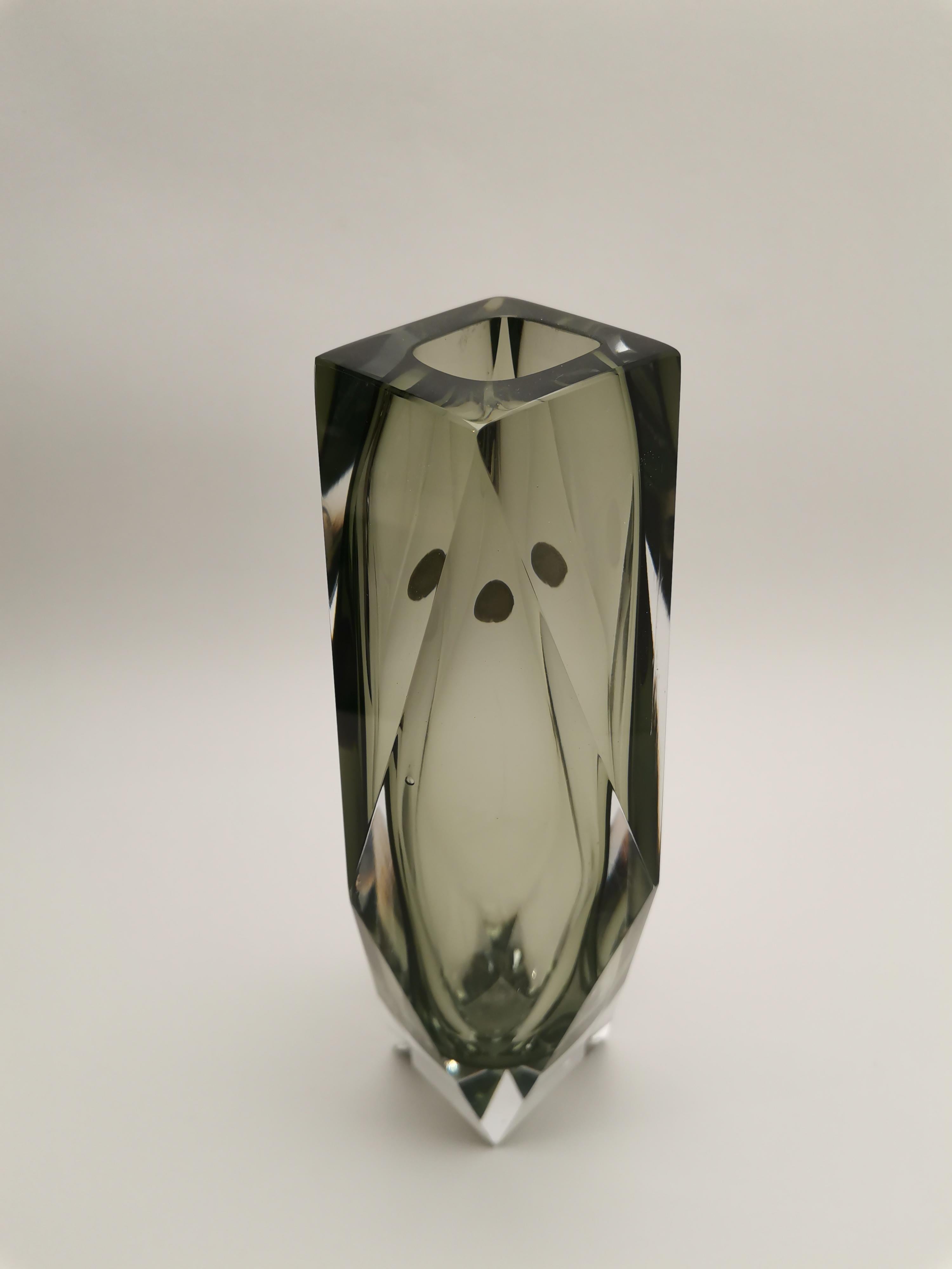 Questo splendido vaso Sommerso presenta un vetro sfaccettato in bellissime tonalità di grigio, realizzato con l'iconica tecnica Sommerso. Il vaso presenta un vetro grigio scuro e chiaro incastonato in un vetro trasparente, attribuito al rinomato