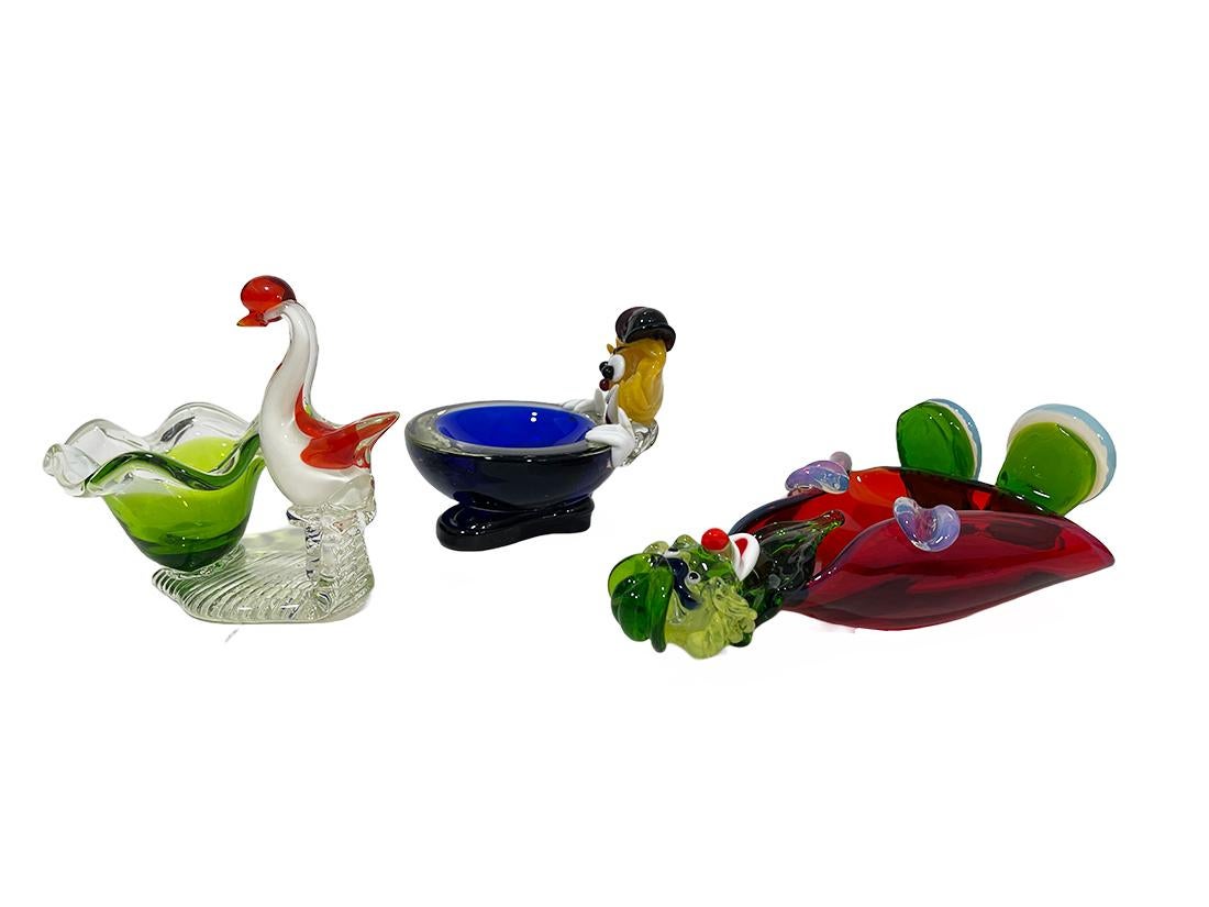 Murano Venetian glass clowns and swan, Italy, 1970s

A Murano Venetian, glass clown bowl and ashtray and a swan with bowl.
A round thick glass blown bowl with a clown supposedly underneath with a funny big smile. A clown as an ashtray can be