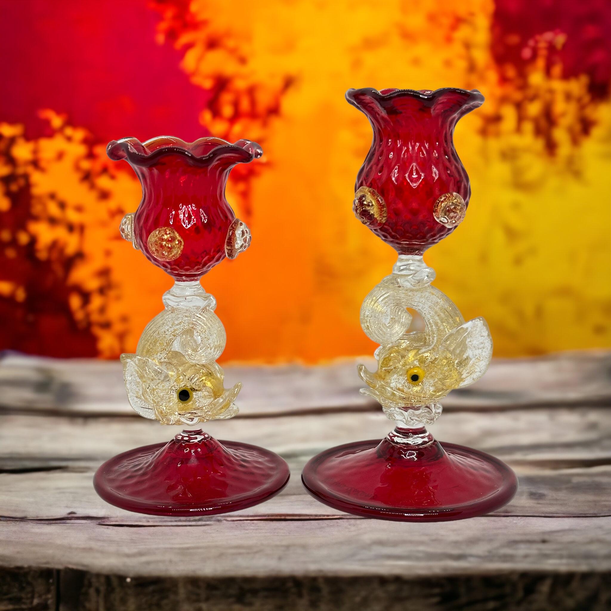 A beautiful set of two Venetian art glass dolphin candle holders. These Murano glass candle holders on display add a touch of luxury to any occasion. This unique, 100% hand-blown masterpiece is characterized by great attention to detail. Ruby red