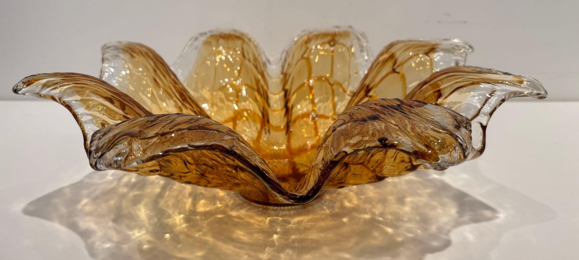 Splendida ciotola decorativa in vetro artistico soffiato a mano di Murano color ambra.
Grande ciotola in vetro artistico di Murano con sfumature ambrate e cristallo trasparente
Questa splendida ciotola è un vero e proprio Objet d'art e può essere