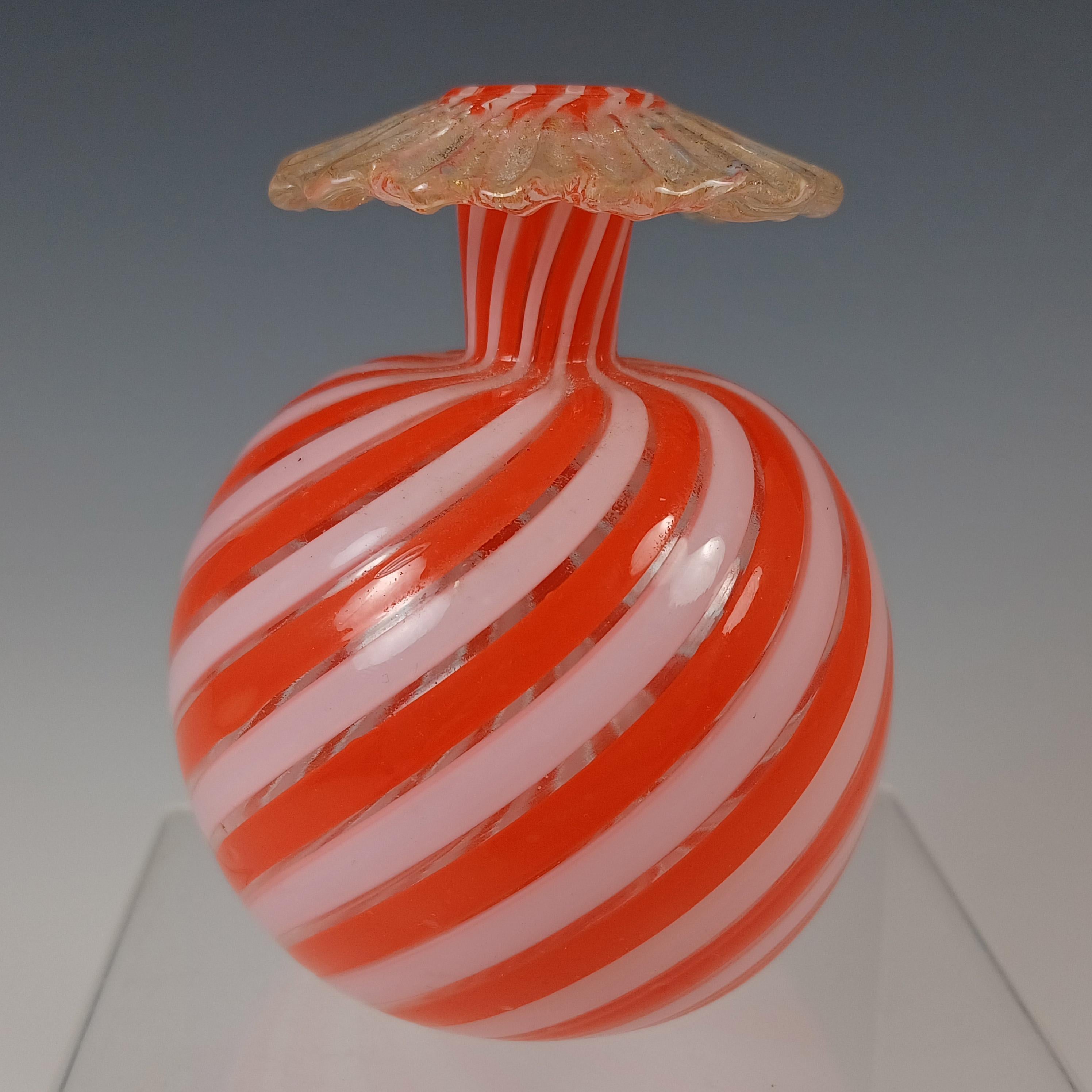 Hier ist eine wunderbare kleine venezianische Glasvase, hergestellt auf der Insel Murano, in der Nähe von Venedig, Italien. Verziert mit Streifen aus orangefarbenen und weißen Filigransträngen, mit appliziertem Klarglas-Rüschen-Dekor um den Rand,