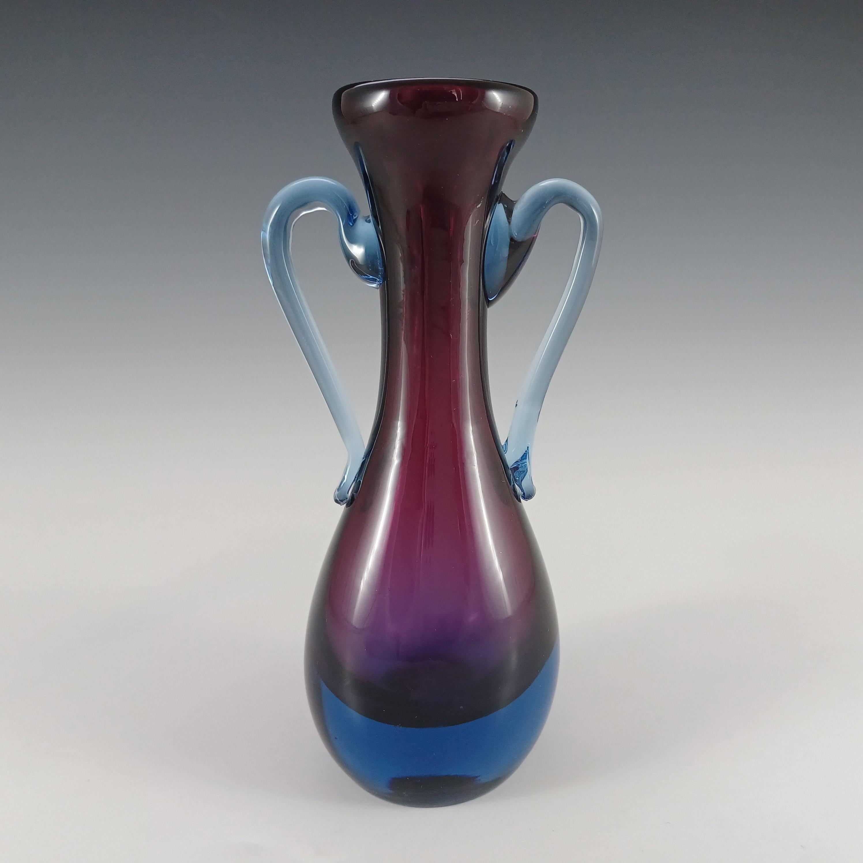 Voici un magnifique vase en verre vénitien, fabriqué sur l'île de Murano, près de Venise, en Italie. Dans une étonnante combinaison de verre violet et de verre bleu, selon la célèbre technique vénitienne du sommerso, avec une poignée bleue