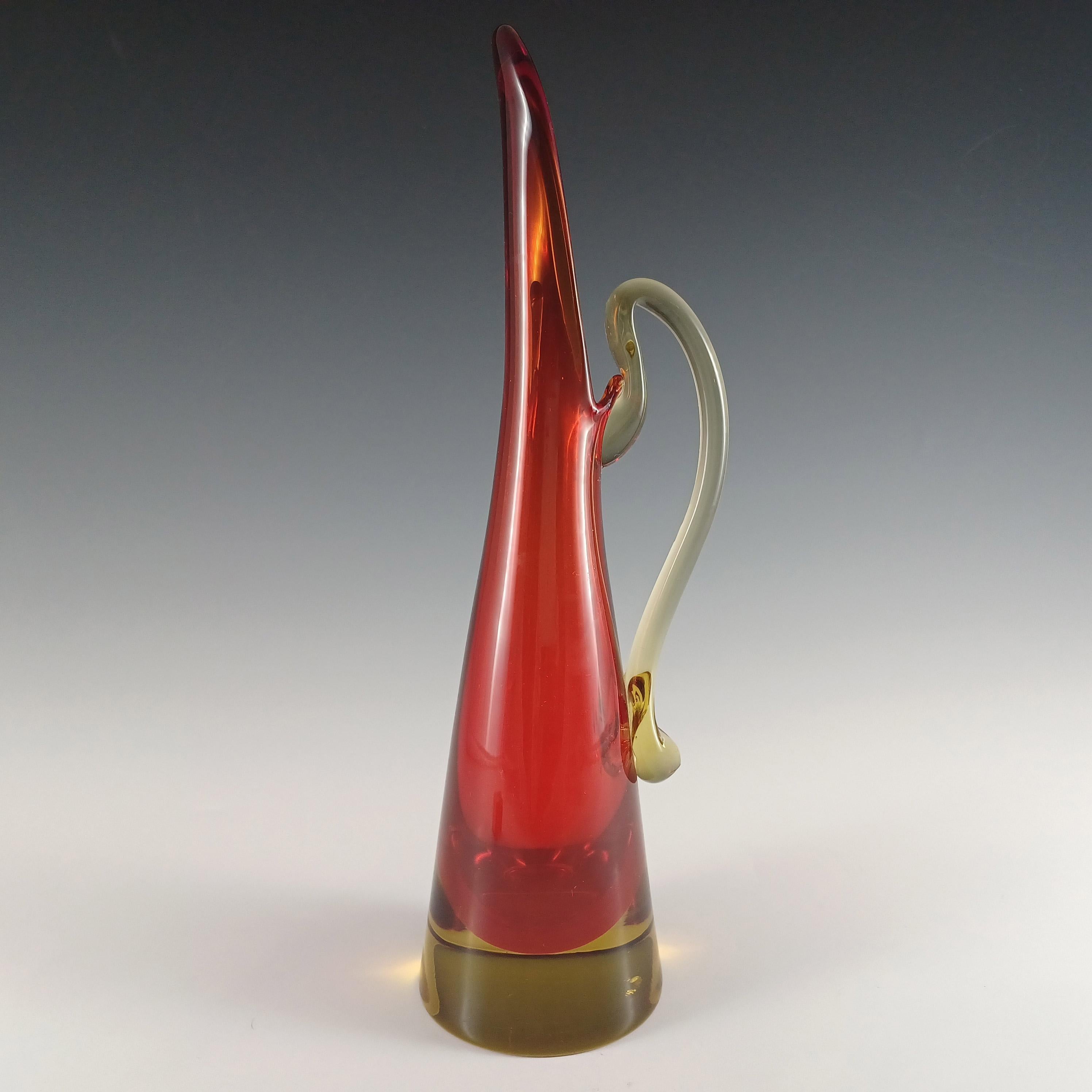 Jarrón alto de tallo de cristal veneciano al estilo de una jarra, fabricado en la isla de Murano, cerca de Venecia, Italia. En una asombrosa combinación de vidrio rojo envuelto en vidrio ámbar, utilizando la renombrada técnica veneciana del