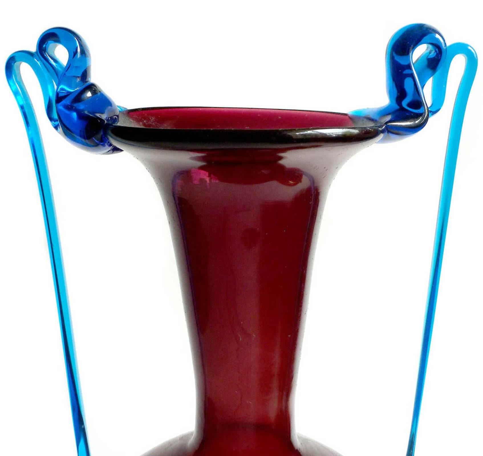 Gorgeous and delicate antique Murano hand blown burgundy red and cobalt blue Italian art glass double handle vase. Attributed to the Fratelli Toso Company, circa 1930s or earlier. Created in the Venetian style. The piece has very thin applied long