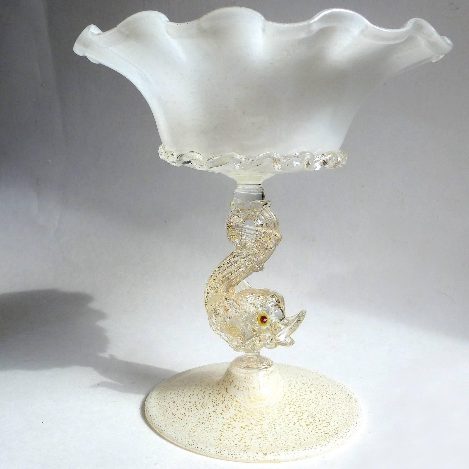 Priced per item (2 available as shown). Gorgeous early Murano hand blown white and gold flecks Italian art glass compote bowls with fish stems decoration. Both are almost identical, except one is a little taller. They have an applied rigaree ribbon