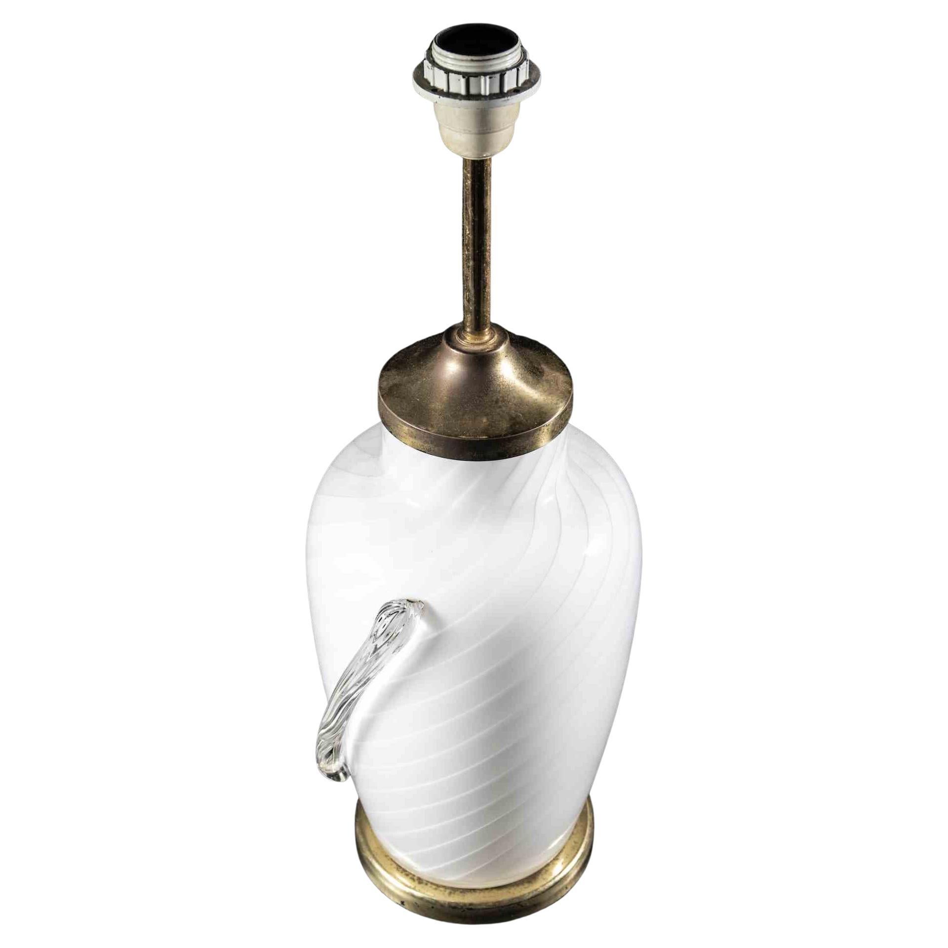 Die Murano-Tischlampe ist eine originelle Lampe, die in der Hälfte des 20. Jahrhunderts von einem italienischen Designer entworfen wurde.

Eine Vintage-Lampe mit einem Körper aus weißem Muranoglas und eleganten Messingkanten.

Neuwertiger