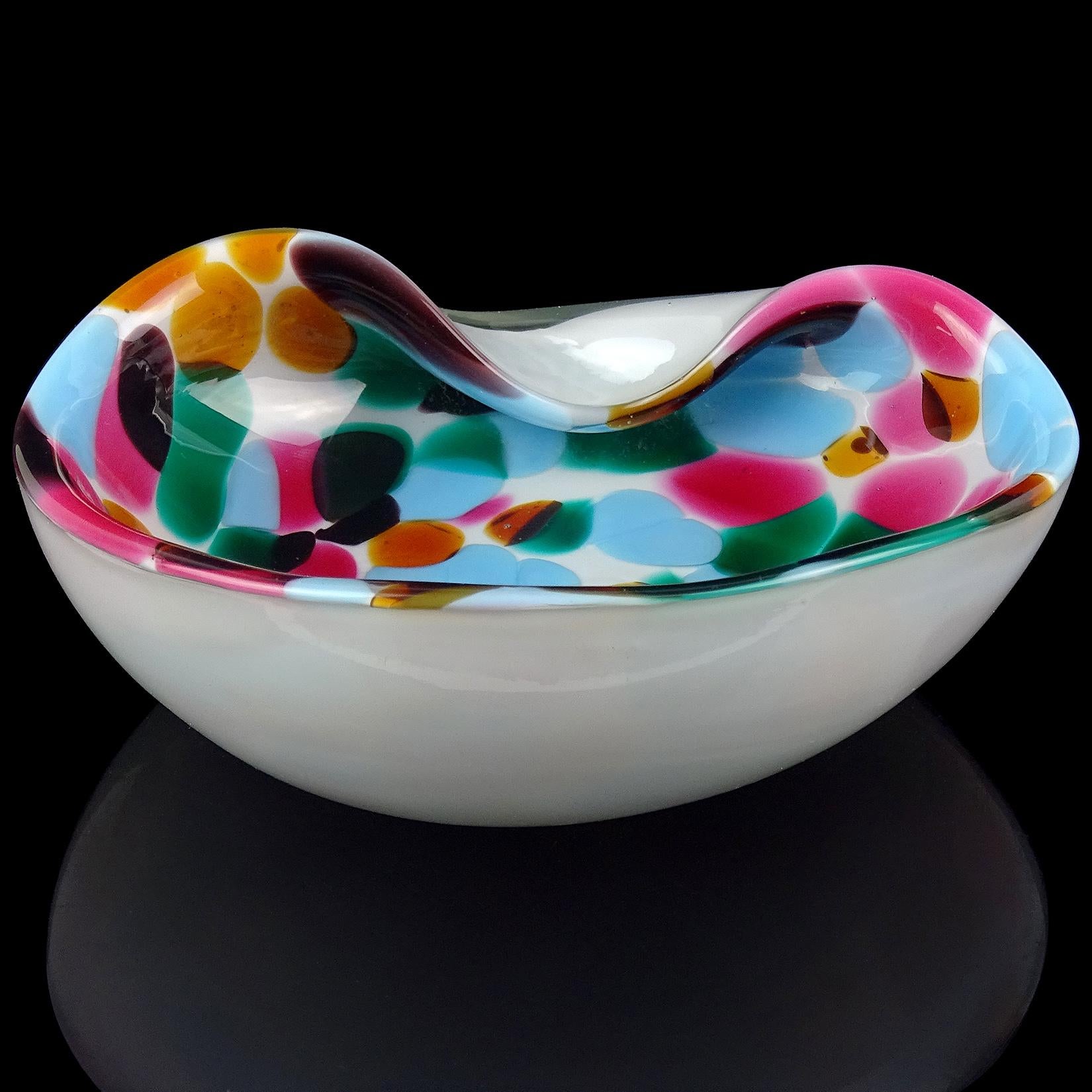 Beautiful vintage Murano hand blown white with deep pink, blue, green and orange spots Italian art glass bowl / vide-poche. It has a decorative indent on the rim. In the manner of Alfredo Barbini. Would make a great display piece on any desk, vanity