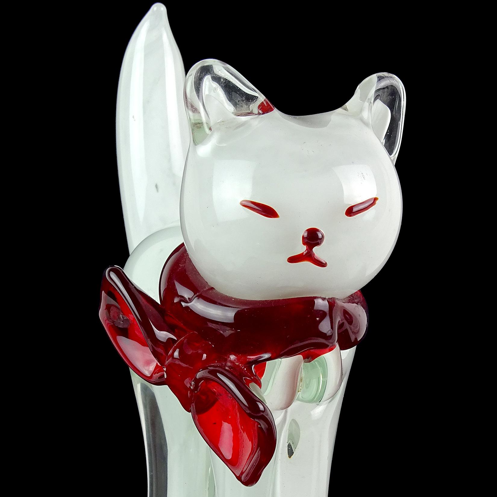 Beautiful and extra large, vintage Murano hand blown clear glass over white Italian art glass kitty cat sculpture. It has red accents for its cute face, and a large red bow on its neck. The cat stands on a large clear glass base that encompasses its