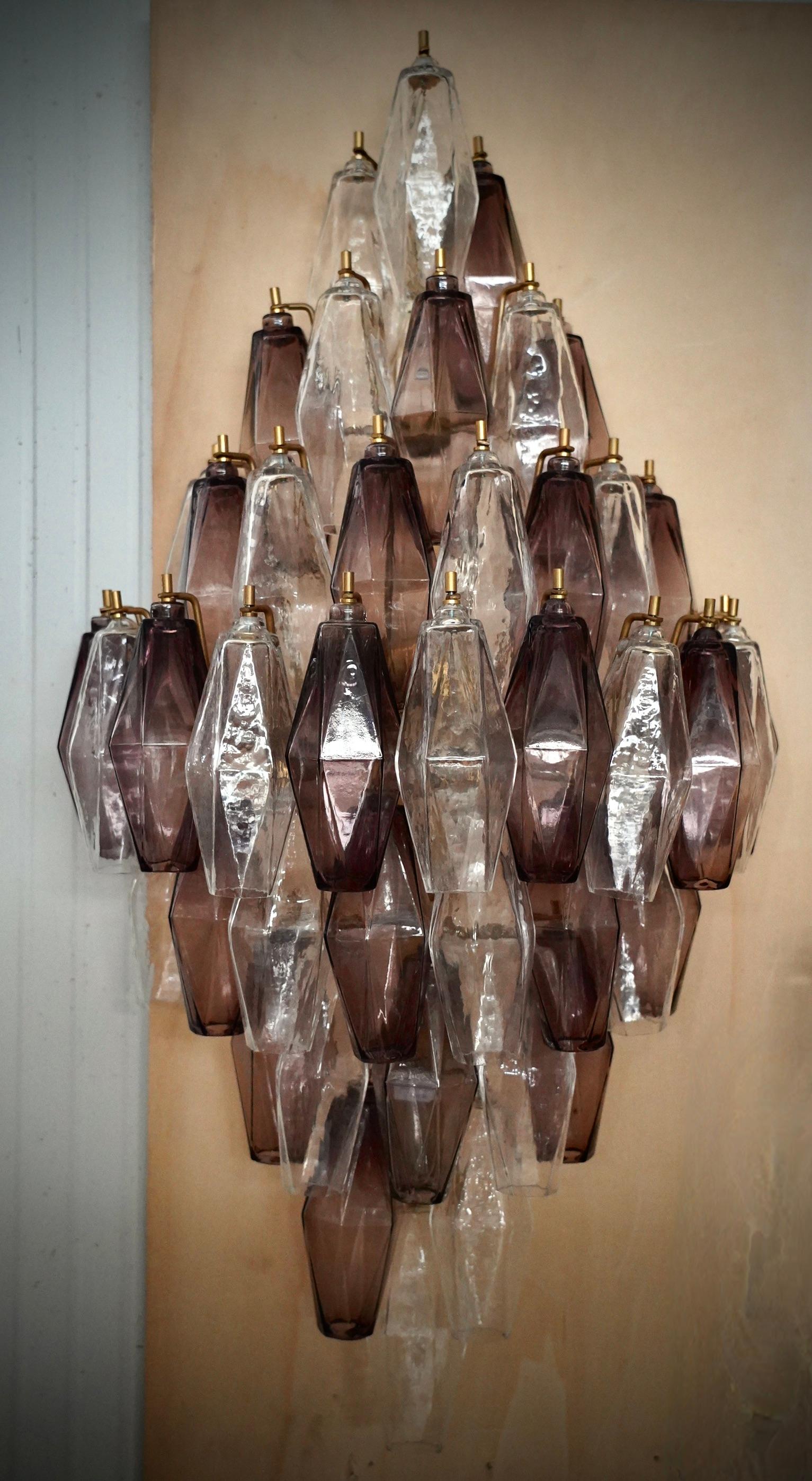 Tanti bellissimi tetraedri nel classico vetro di Murano viola e trasparente. Un design ricco per un'applique davvero bella. Semplice ed elegante come nello stile Mazzega.

L'applicazione è composta da una serie di tetraedri in vetro di Murano di