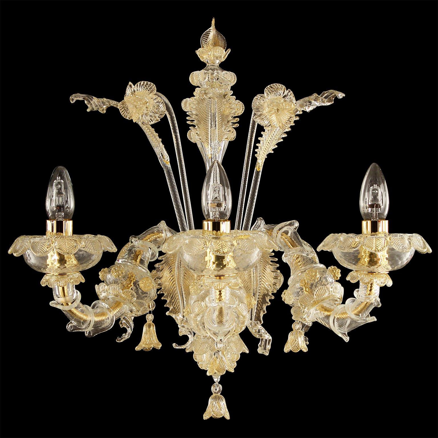 Caesar wall 3 lights, Venetian style, clear blown artistic glass and gold details by Multiforme
The name, as well as the structure evokes the splendour of the past centuries. It is an evergreen model, a classic product manufactured by our skilled