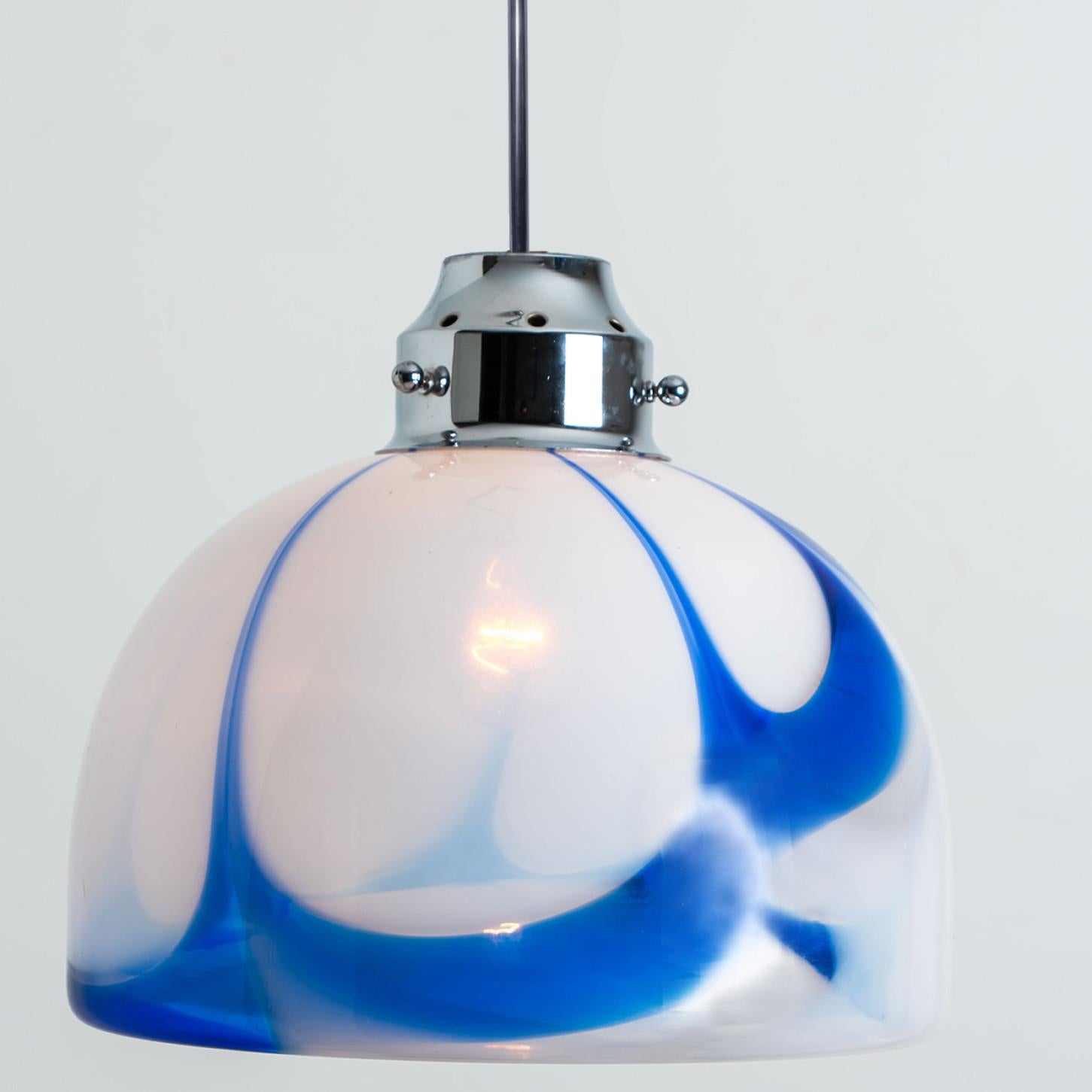 Beautiful white and blue pendant light of murano glass. Manufactured in Italy, Europe, around 1970. The Italian murano glass is hand blown.
The white opaque glass shows marbled blue pattern. The fixture is made of a chrome suspension.
The light