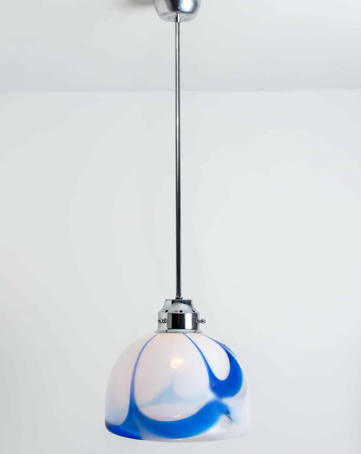 Beautiful white and blue pendant light of murano glass. Manufactured in Italy, Europe, around 1970. The Italian murano glass is hand blown.
The white opaque glass shows marbled blue pattern. The fixture is made of a chrome suspension.
The light