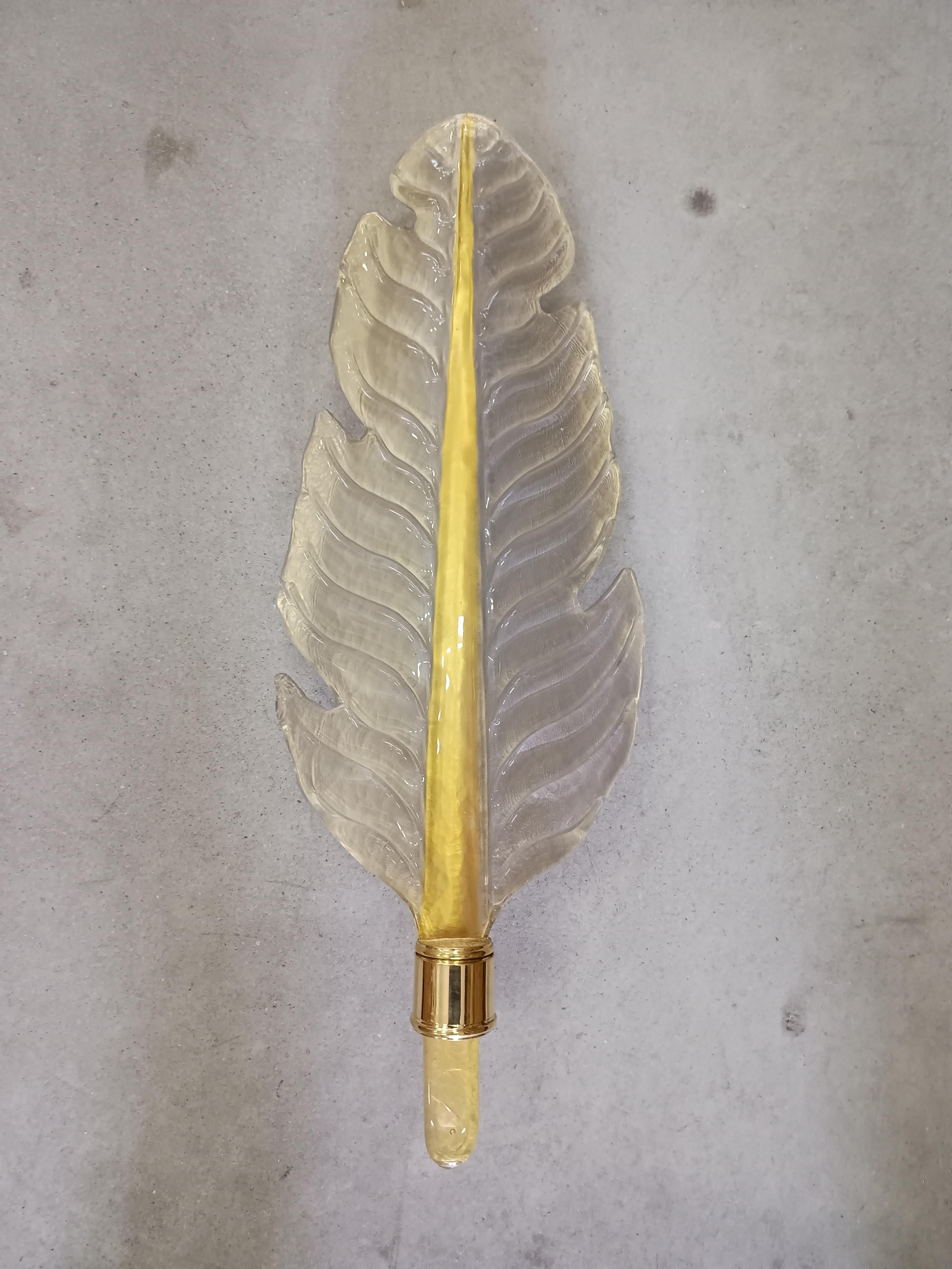 Majestic Murano blown glass leaf with a wonderful white and gold color, made even more beautiful by its polished brass structure. The Murano furnaces create an indisputable timeless design

The wall light is composed of a brass structure that is