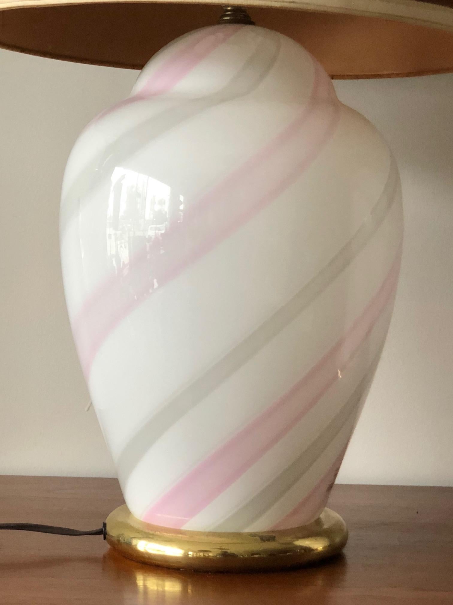 A stylish pair of Murano, cased glass lamps. White with pink stripes, these lamps also light from inside. Glass bases measure approximate 9