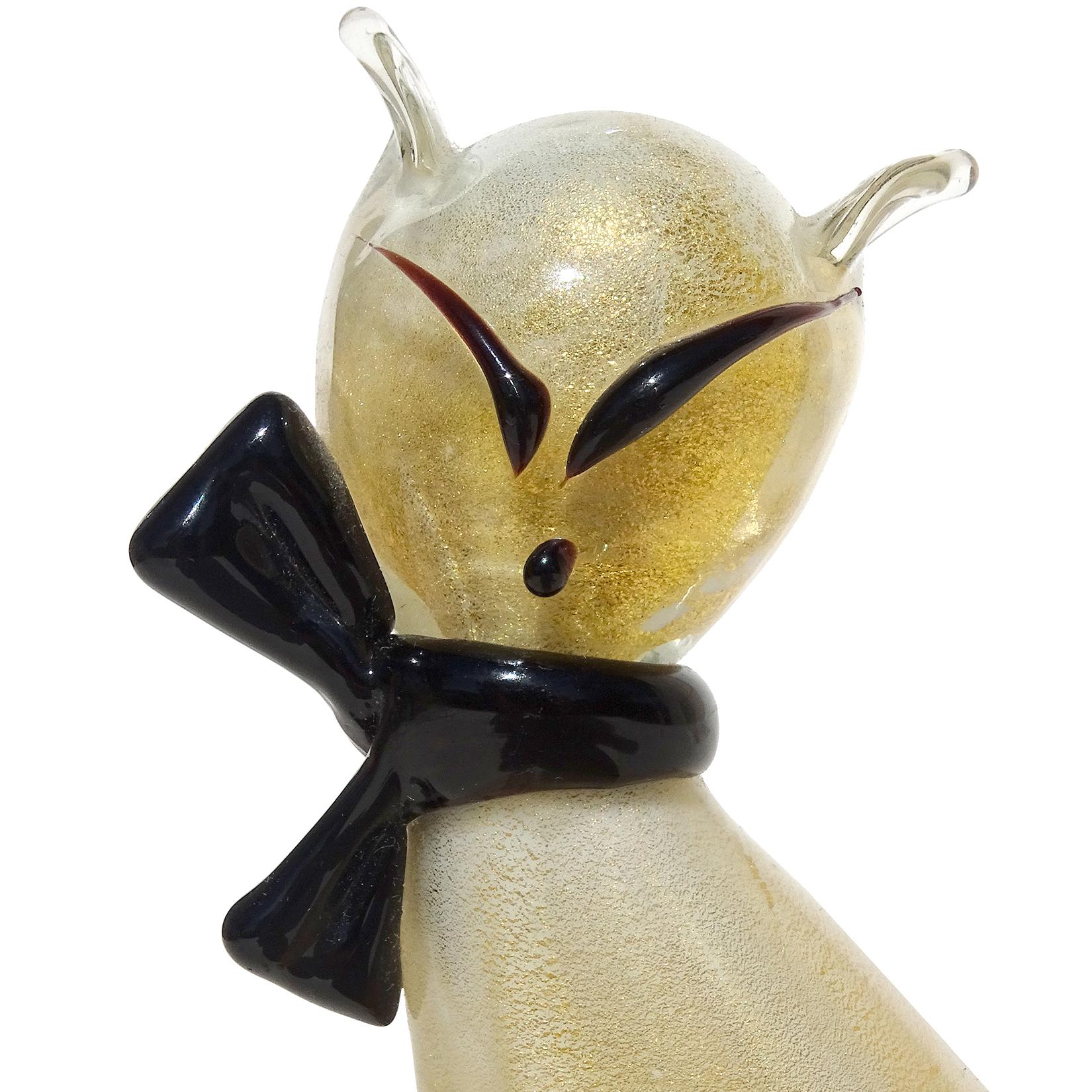 Beautiful vintage Murano hand blown clear over gold flecks Italian art glass kitty cat sculpture. The figure is profusely covered in heavy gold leaf, with black bow around face details. It still retains an original 