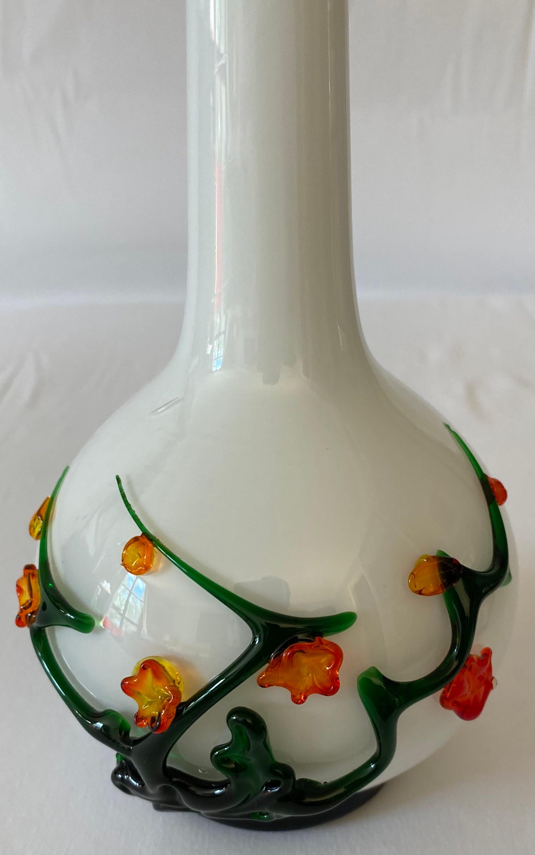 Magnifique vase en verre d'art soufflé de Murano avec décoration florale appliquée.

Le joli décor floral est appliqué à chaud sur un fond blanc. Idéal pour exposer vos fleurs préférées. Il rehausserait n'importe quelle étagère, table ou comptoir.