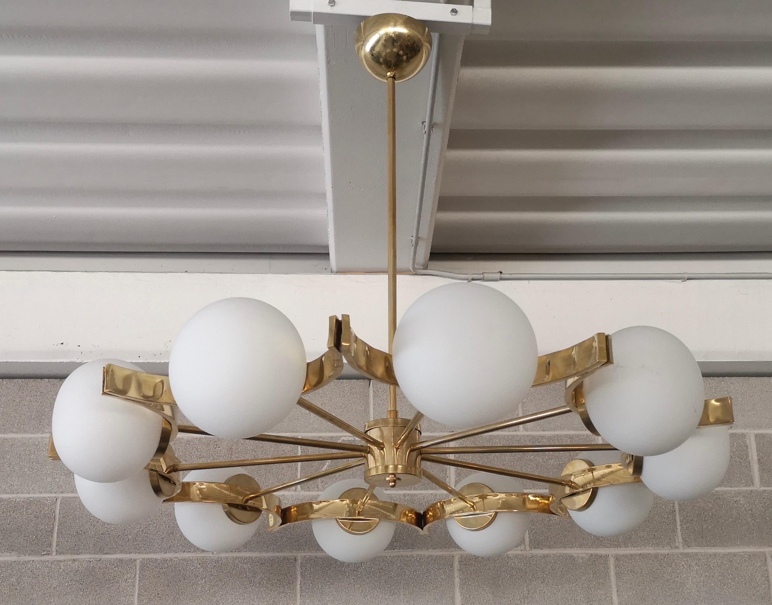 Superb chandelier for its characteristic concave circular structure, unique design for the brass housing of the spheres.

The chandelier has a polished brass structure, it is composed of a series of brass concave circular joined all together. In the