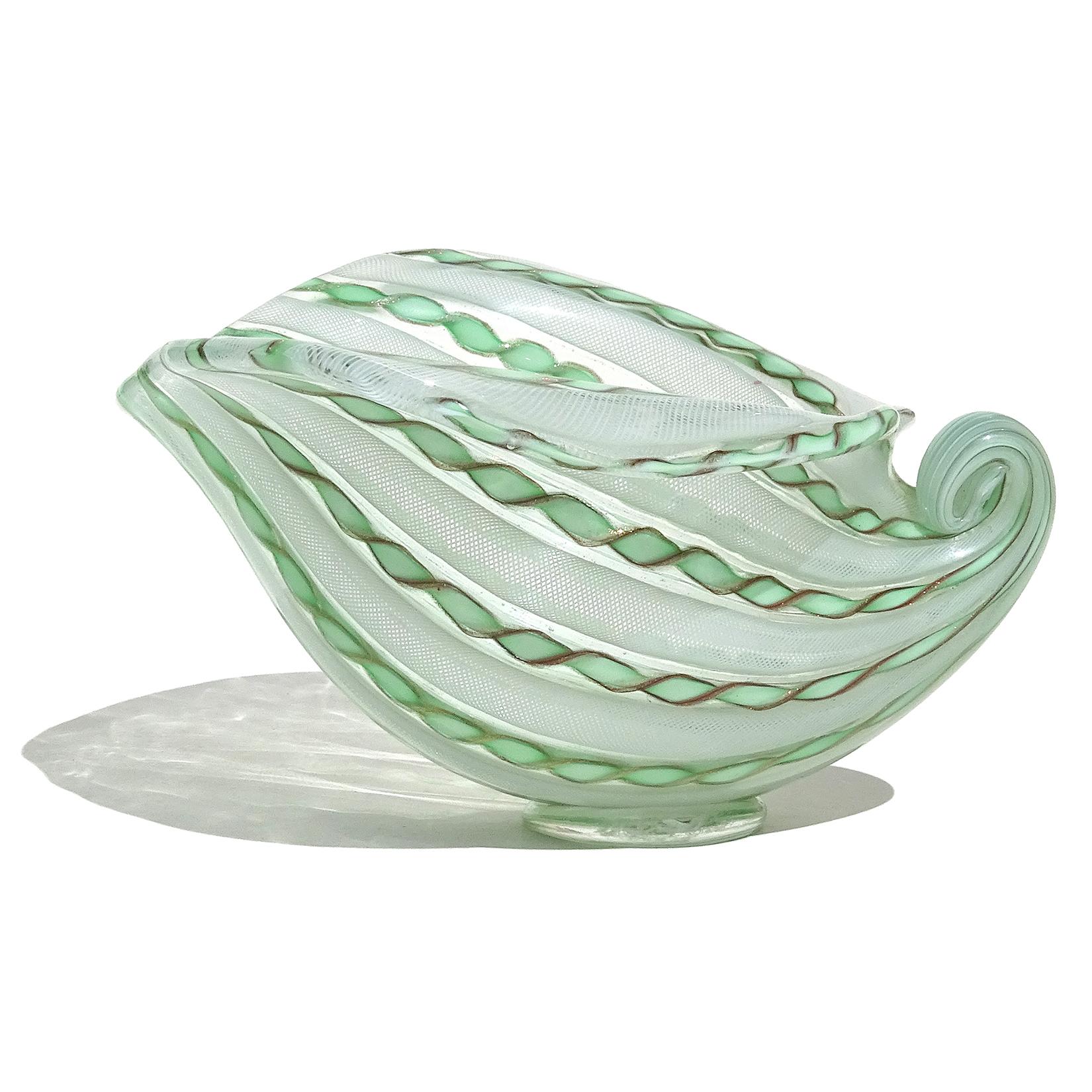 Beautiful vintage Murano hand blown white and green ribbons Italian art glass seashell shaped bowl. Attributed to designer Dino Martens for Aureliano Toso, circa 1950s. The shell has an alternating stripe pattern, with tight white net Zanfirico and